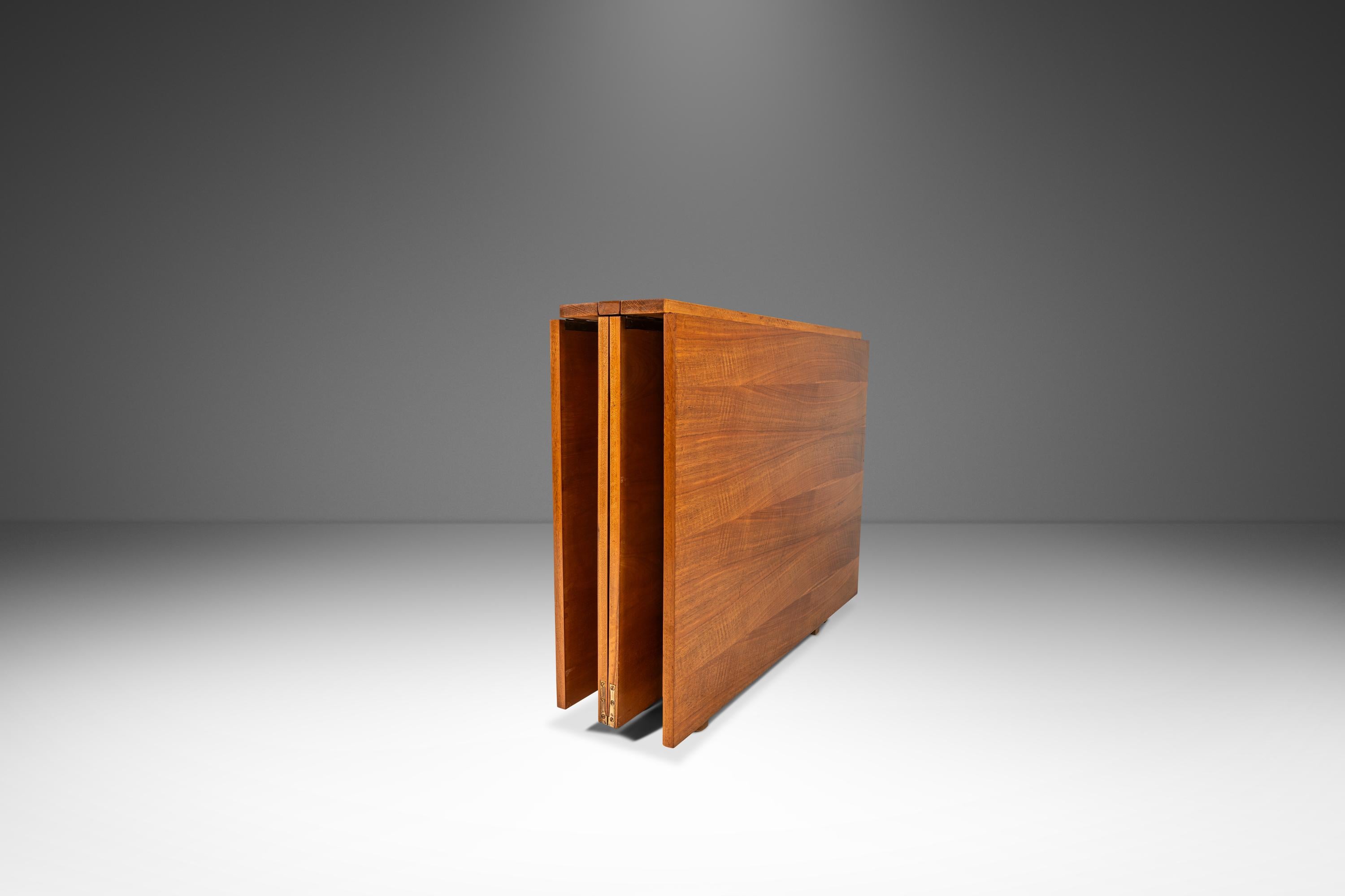 This remarkable expanding table, inspired by Bruno Mathsson's renowned 'Maria Flap' design, showcases the ingenuity of 1960s European craftsmanship. Constructed from European walnut, the tabletop features stunning book-matched veneers, highlighting