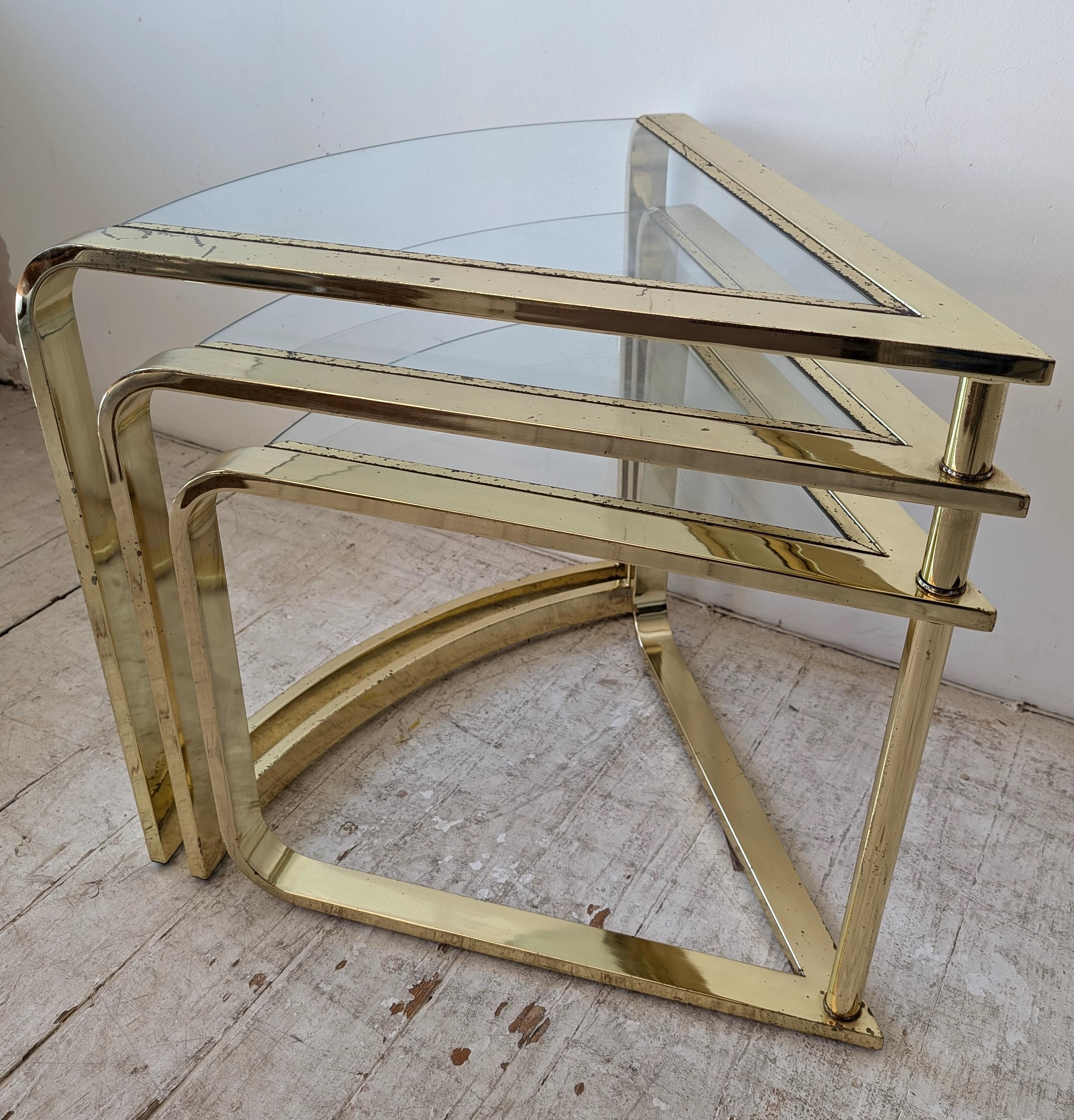 Rare vintage expanding three tier coffee table by Design Institute of America (DIA), 1980s. The 3 wedge-shaped tables are on a central pivot, enabling them to be nested together, or spread out in a circular shape.
Frames are shiny gold metal.