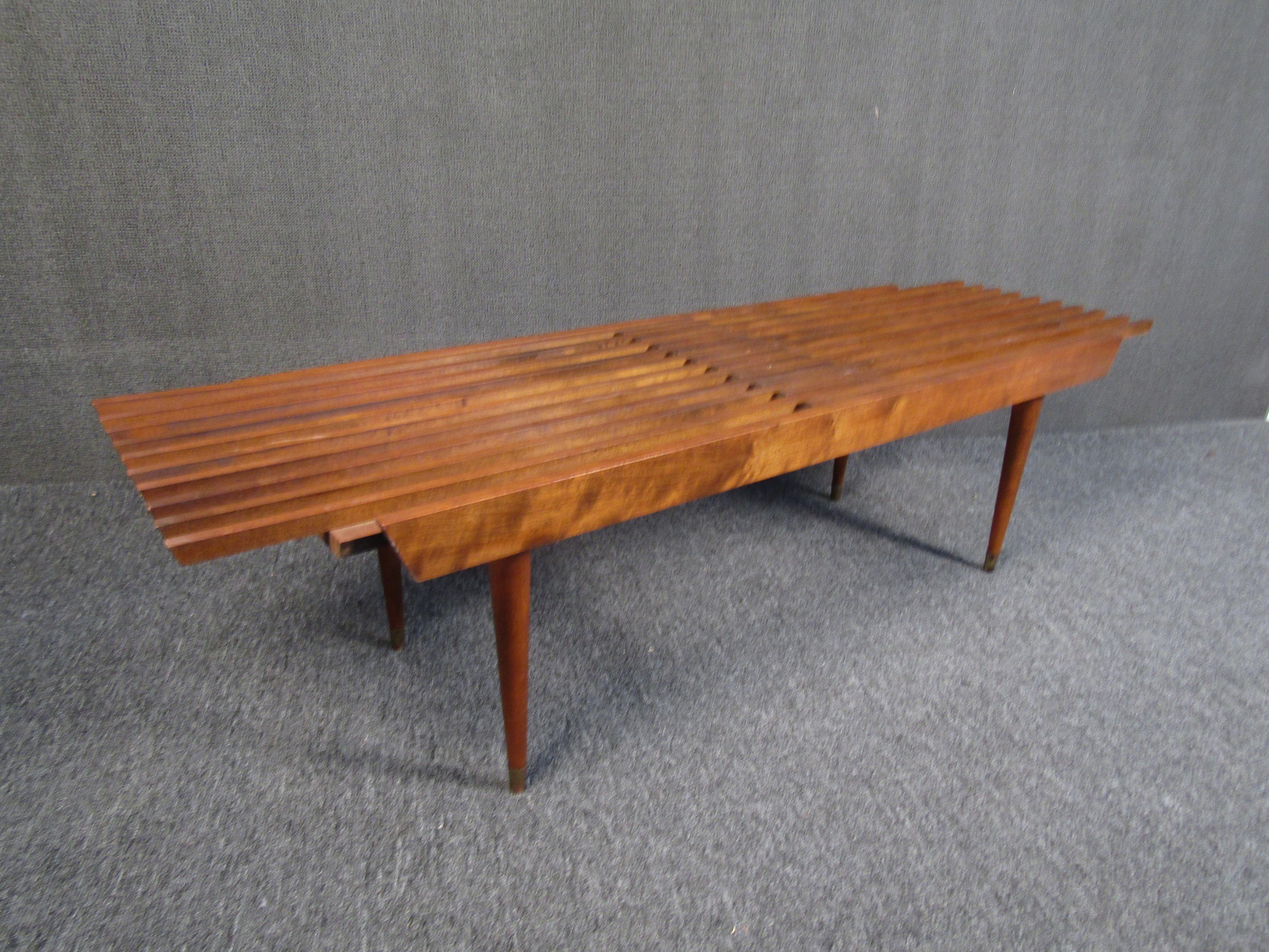 One of a kind vintage modern slat bench that extends in width. A great piece for any entryway or seating area, this bench shows off rich woodgrain and tapered legs with metal caps. Please confirm item location with seller (NY or NJ).