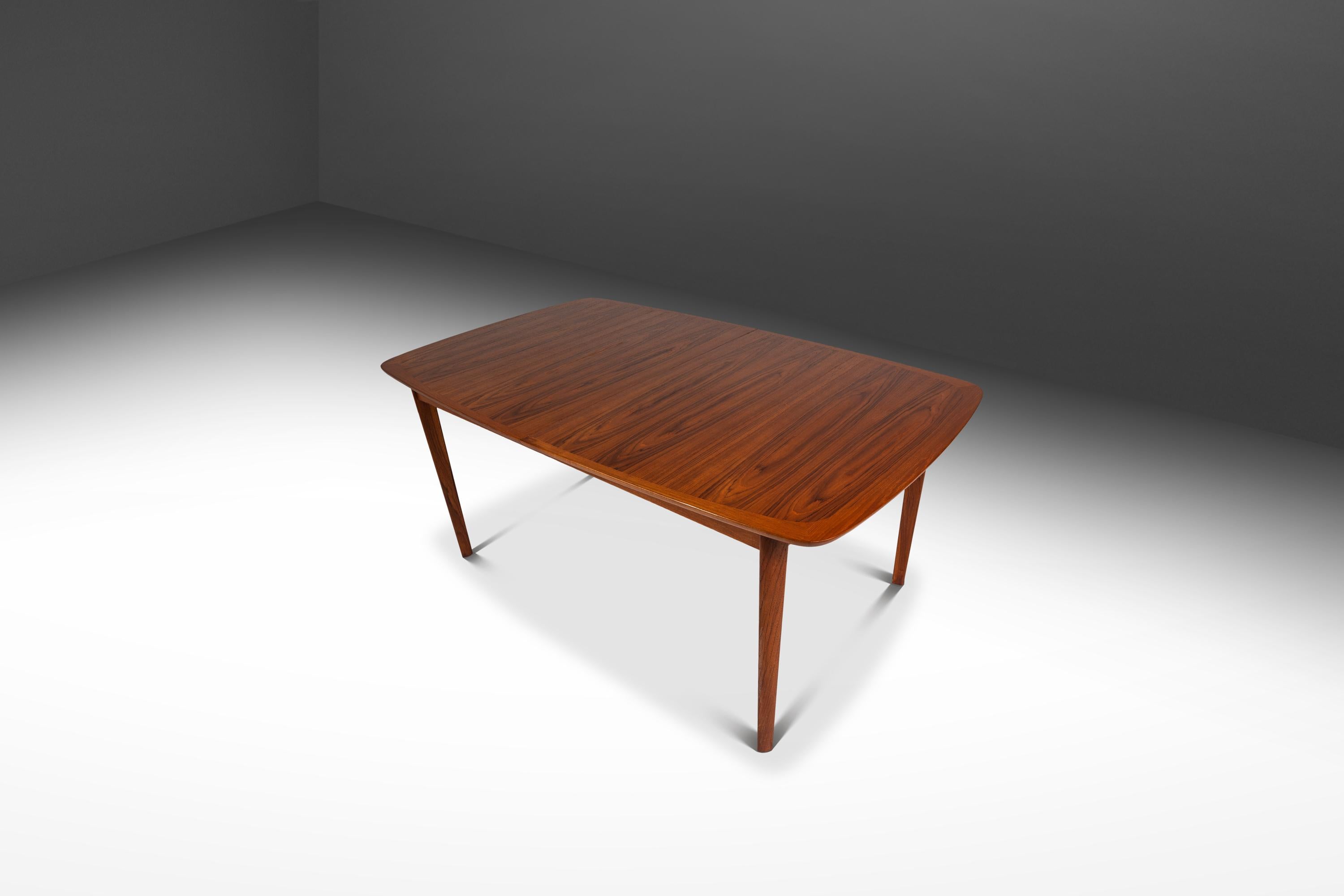 Attention collectors! Introducing a near mint-conditioned extension dining table by the lauded Norwegian Westnofa Furniture Co. Built from a mix of solid and matchbook-veneered Burmese teak with extraordinary woodgrains throughout this artfully