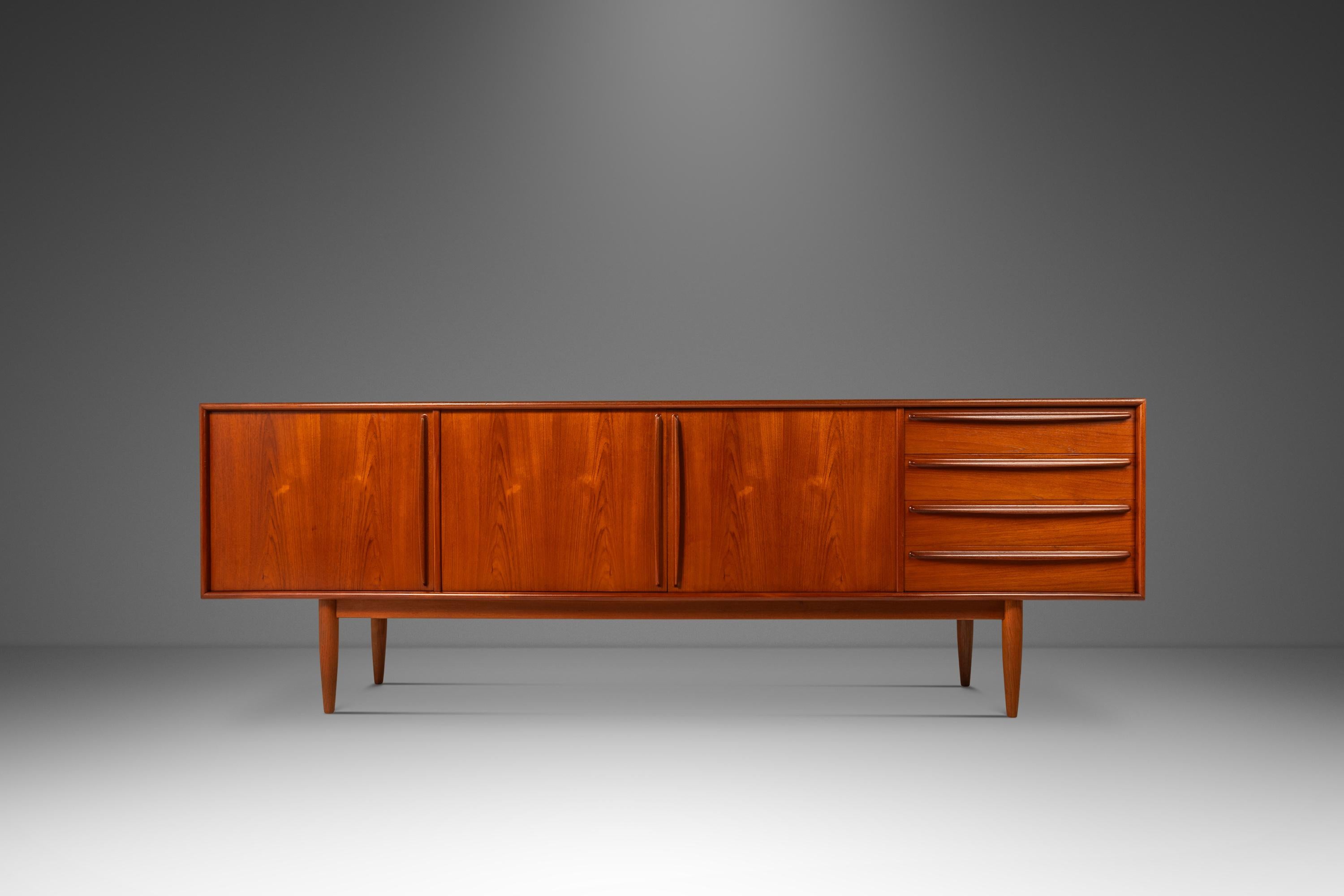 Audacious in scope, design and materials utilized this extraordinary Danish-made credenza is as functional as it is visually arresting. Constructed from a mix of solid and matchbook-veneered Burmese teak this striking sideboard is ideal for