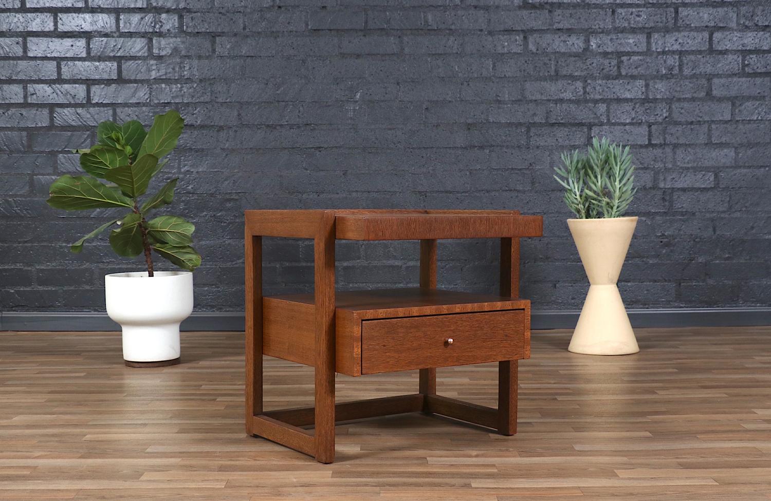 Designed by the renowned Paul Laszlo, this California modern two-tier nightstand embodies both elegance and functionality. Crafted with a warm wood finish, its sleek, clean lines and minimalist form reflect Laszlo’s signature mid-century aesthetic.