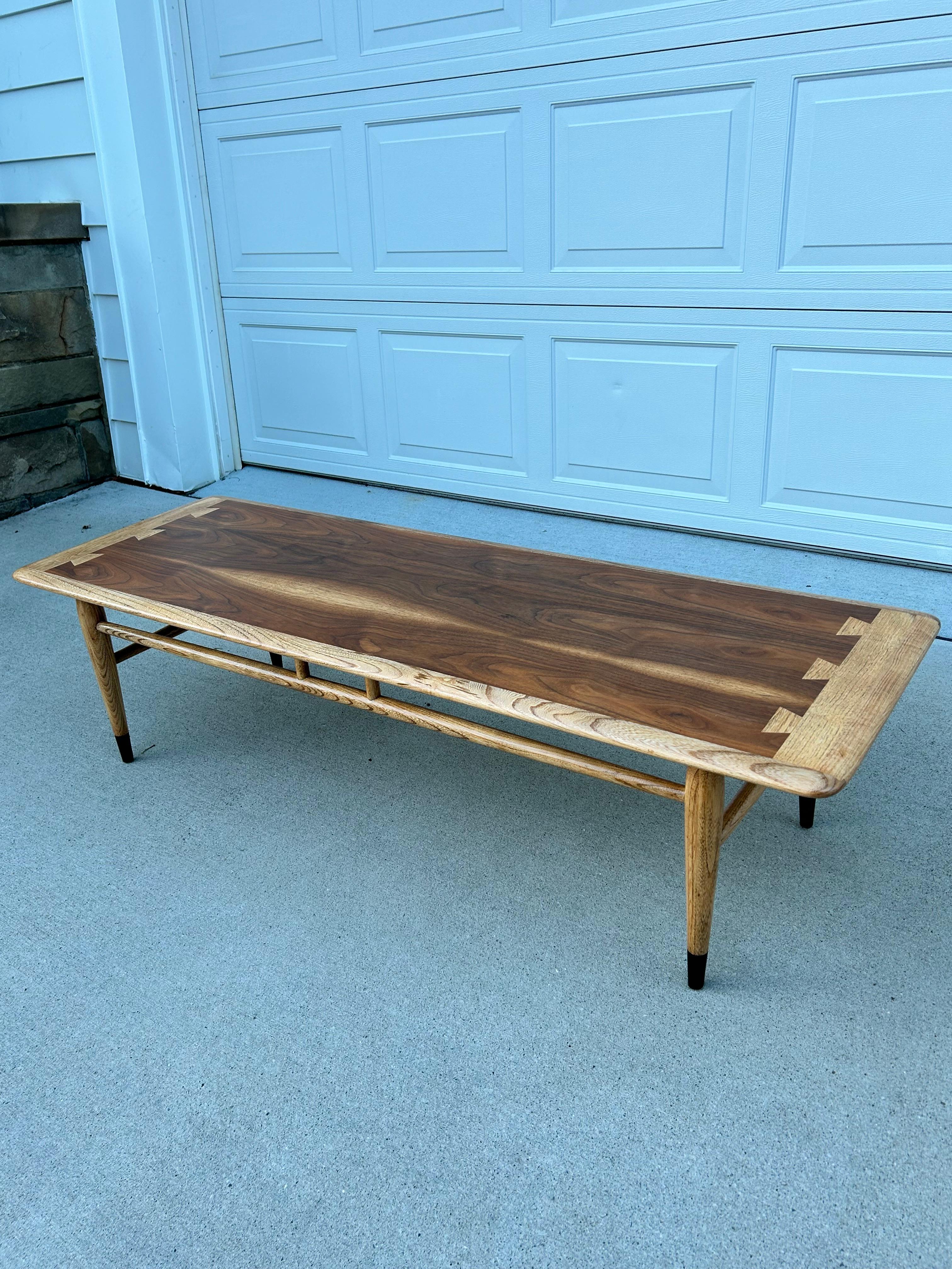 Expertly Restored MCM Lane Acclaim Walnut Coffee Table. This Lane table is designed by Andre Bus, crafted of walnut and blonde oak boarder/dovetail and have beautiful tapered legs with black bottoms. In an amazing condition, sturdy and well made, it