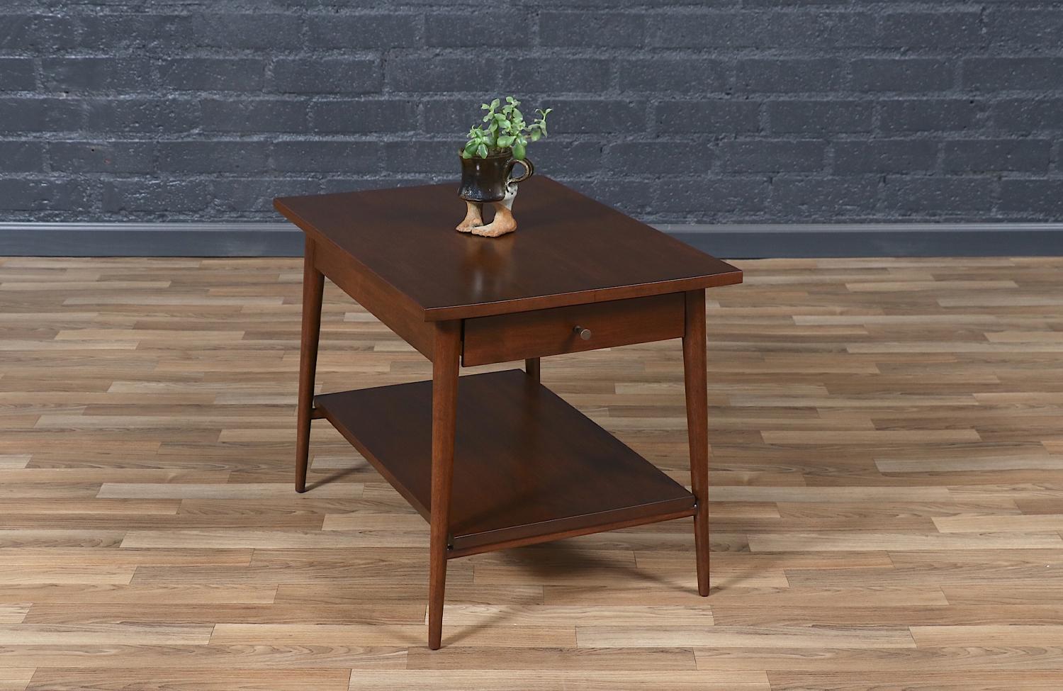 A masterclass in Mid-Century Modern design, this Paul McCobb side table, part of his “Planner Group” line, blends functionality with timeless style. Crafted by Winchendon Furniture Co. in the 1950s, its clean lines, tapered legs, and signature