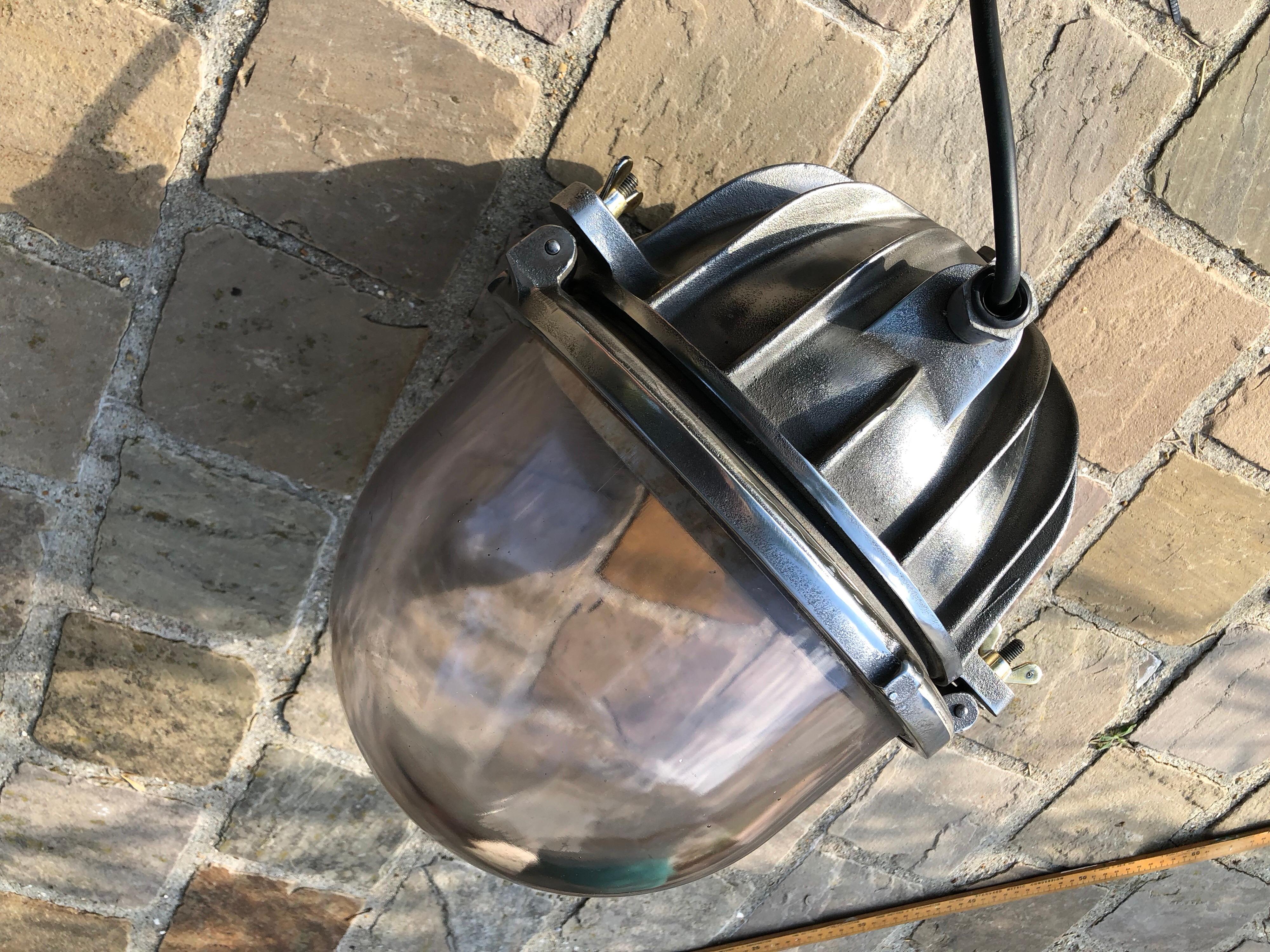 This airfield light is a rare unique Industrial piece of lighting. I has a very thick explosion proof glass dome, very slightly tainted purple, and a massive cast iron base with beautiful metal fins which were designed to evacuate the heat of the