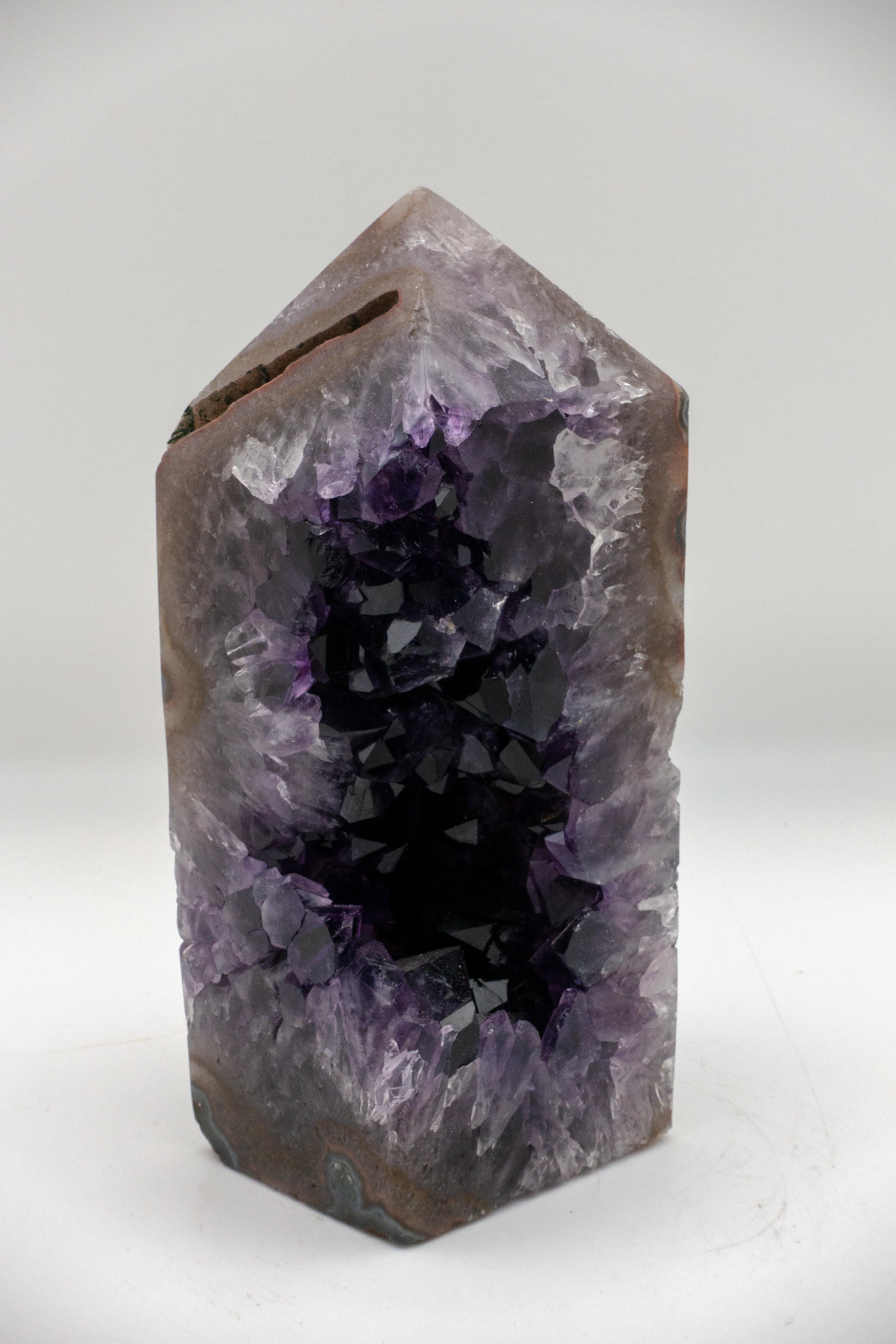 Mineral obelisk with an exposed core of amethyst and an agate exterior.