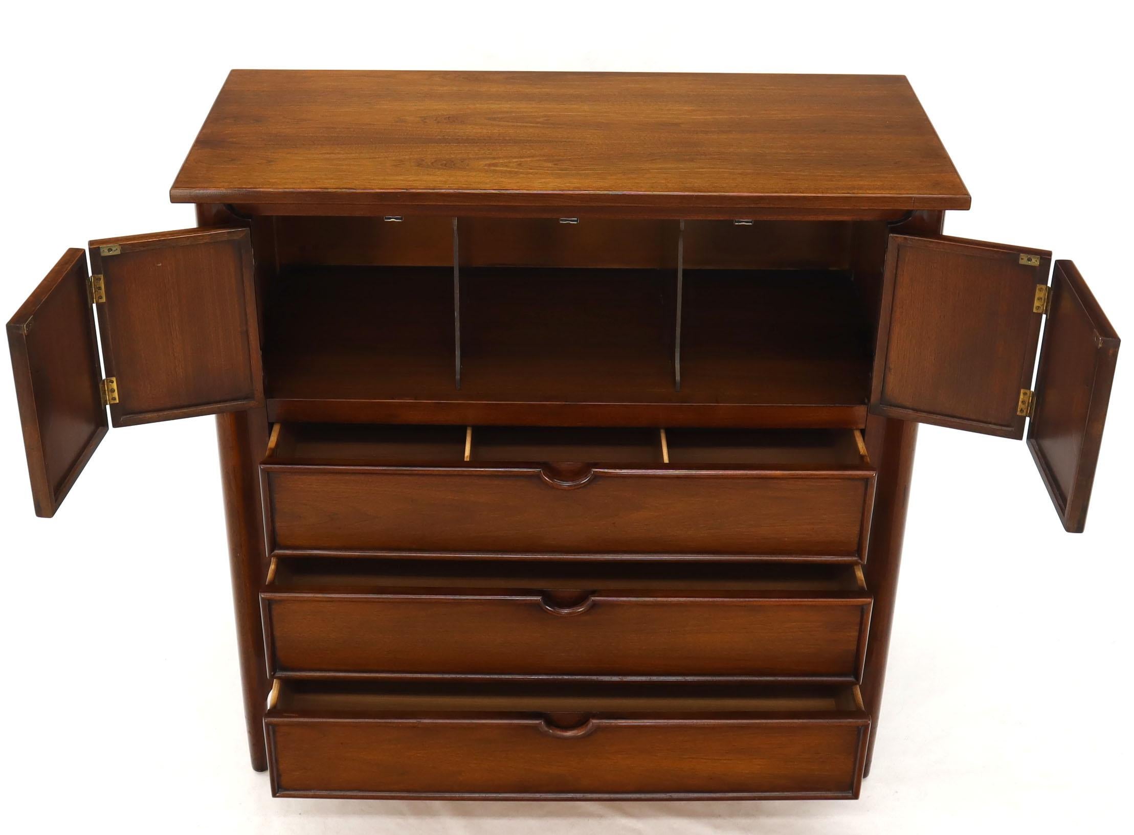 Mid-Century Modern walnut high chest dresser with beautiful exposed sculpted solid walnut legs. Two folding double doors linens compartment with dividers. Nicely sculpted pulls and trim work around the drawers and doors.