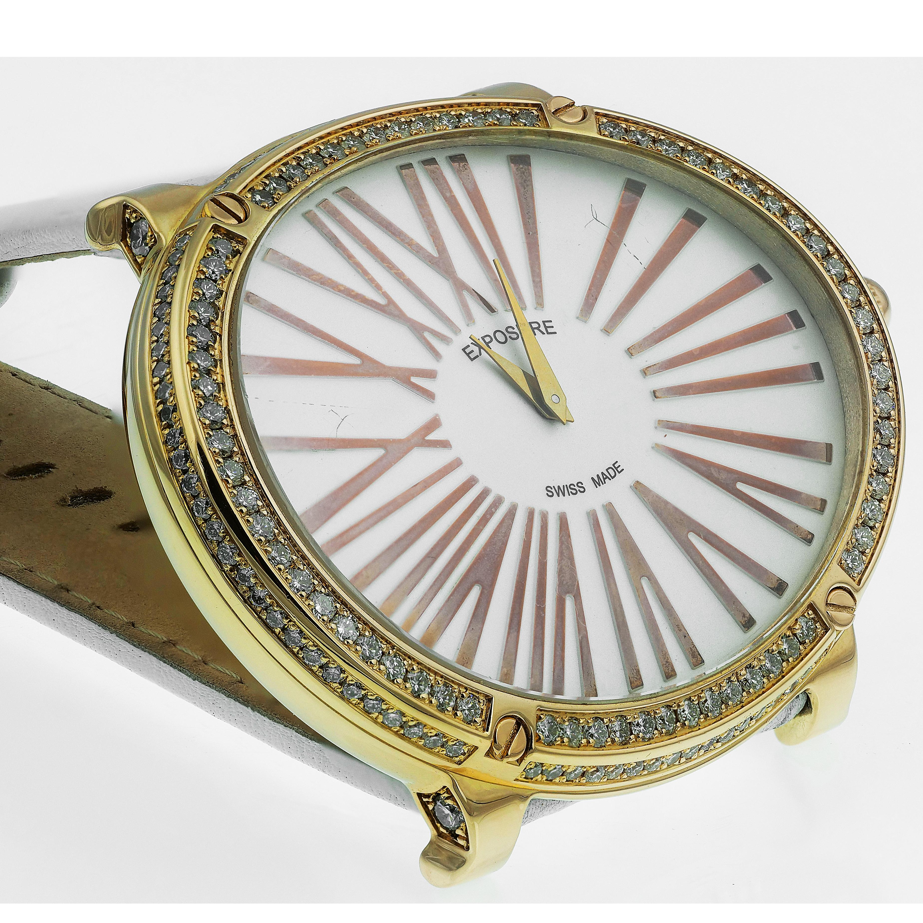 Superbe montre d'exposition avec un cadran blanc, de grands chiffres romains en or et un mouvement à quartz. Une épaisse bordure ovale en or incrustée de diamants ronds de taille brillant scintillants. Les larges bracelets en cuir blanc complètent