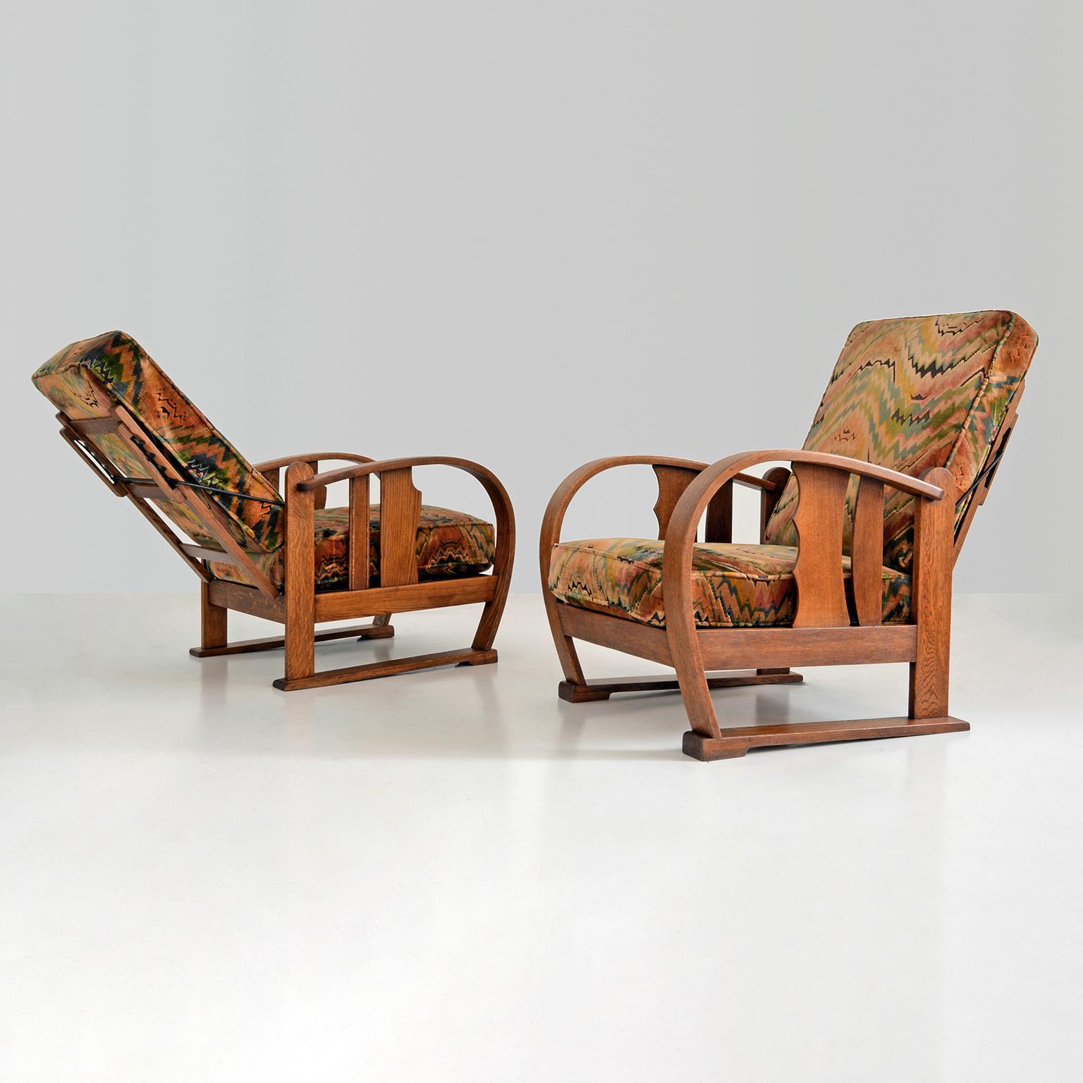 Pair of early Amsterdam School (1910-1930) reclining chairs manufactured c. 1920.
The exuberant appearance characteristic of the movement's first period features 
strong sculptural expressionist lines with elaborate details different from one chair