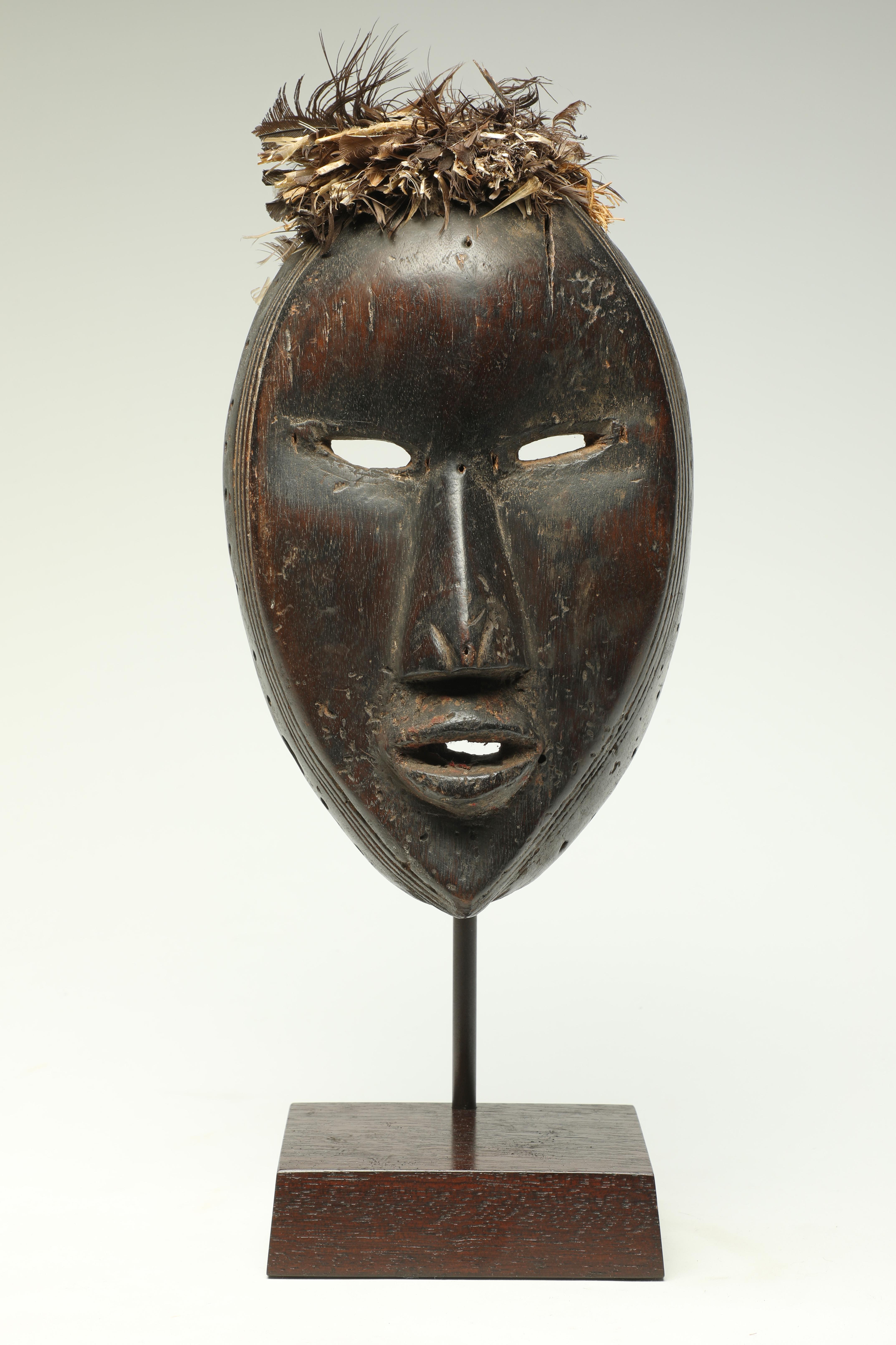 Masque Dan cubiste expressif du début de la période classique, avec un regard expressif raffiné, des yeux et une bouche étroitement ouverts et de fines marques de scarification autour de l'extérieur du visage. Créé au début du 20e siècle par le