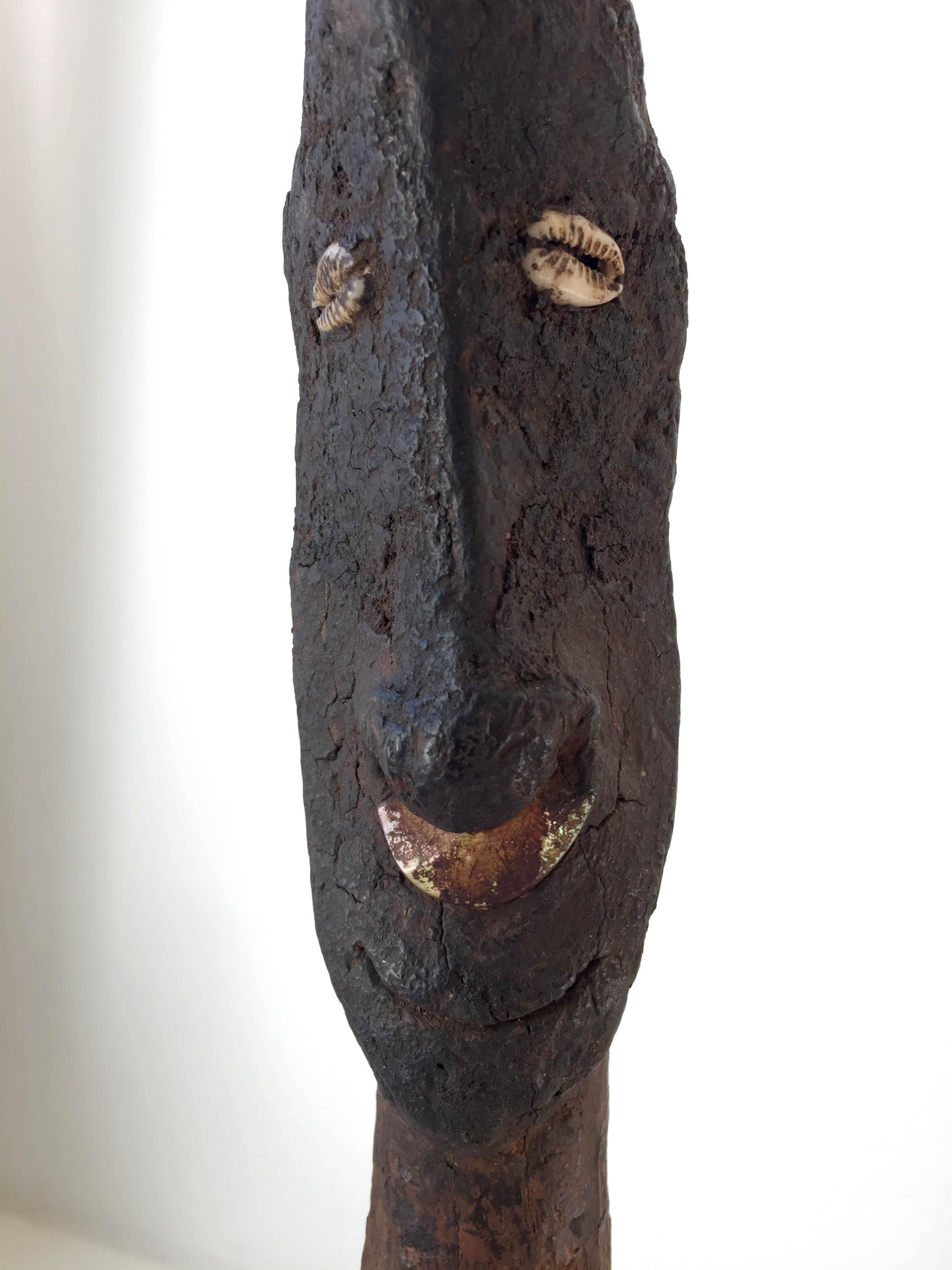 A very old and beautifully encrusted stopper. This intriguing and expressive Middle Sepik area stopper comes from the John Friede Collection. Featuring a stylized anthropomorphic face of an ancestral totem figure with cowry shell eyes and shell nose
