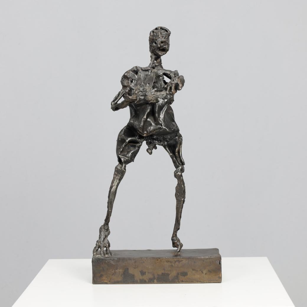 An evocative and expressive iron sculpture by artist Anthony Binstead, created in the 1980s. The figure, built from welded metal sheets, conveys both strength and fragility. Its rough surface and elongated proportions evoke a deep sense of humanity