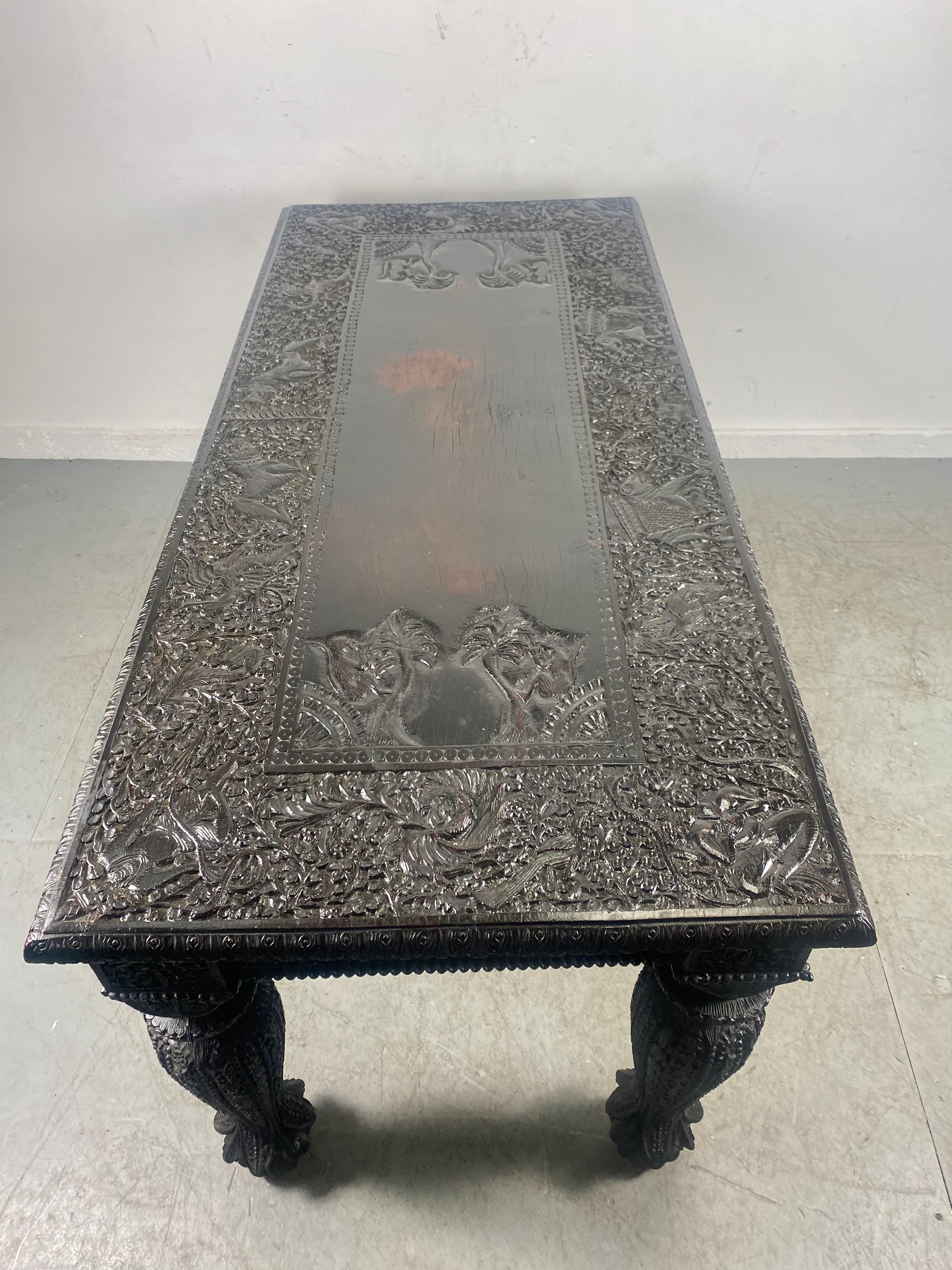 ExquisItely carved Turn or the century Anglo Indian Table, dining/desk/library. Amazing detailing, hand carved animals, elephants, monkeys, Deities (each corner). Hand delivery avail to New York City or anywhere en route from Buffalo NY.