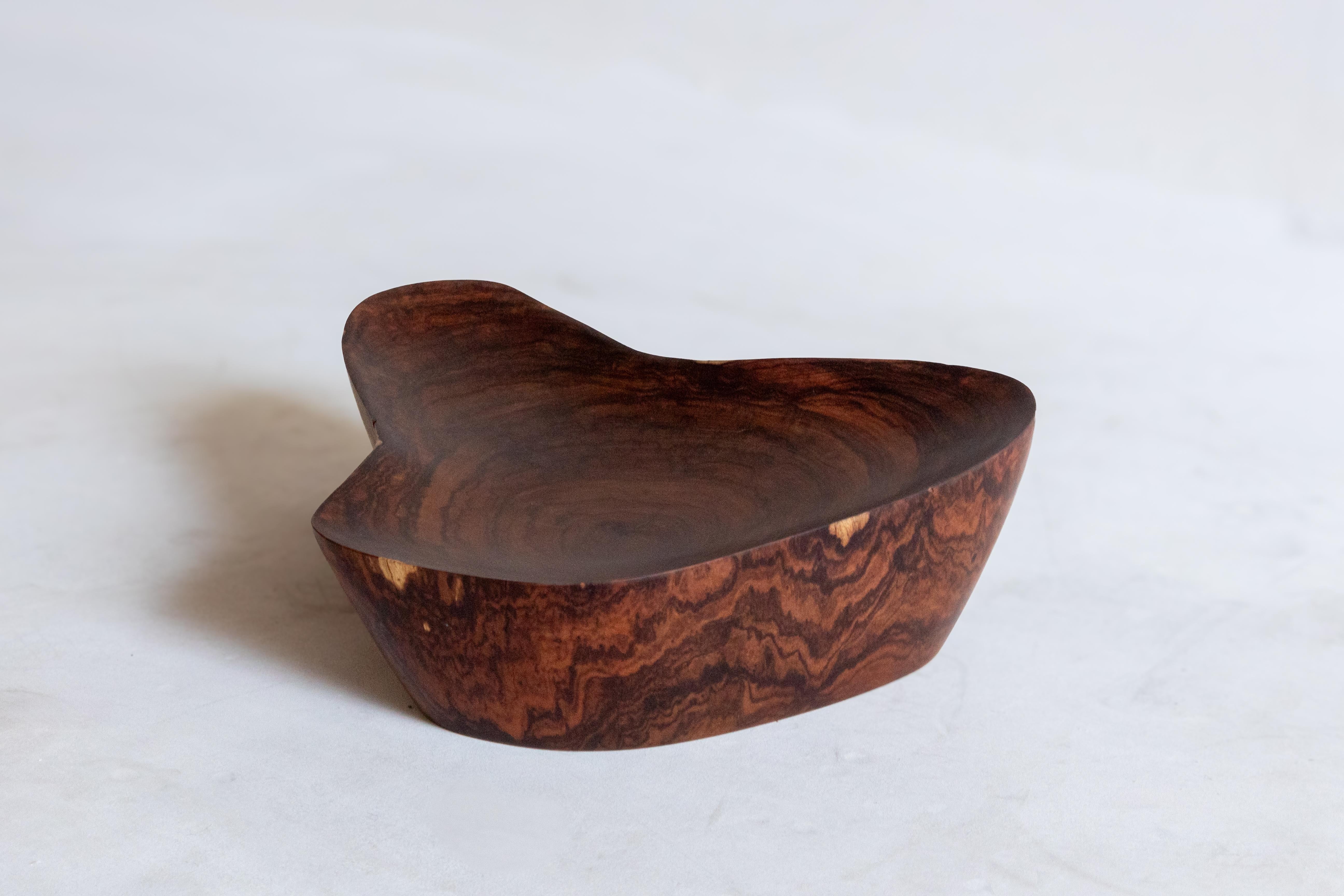Élevez votre espace avec une trouvaille vraiment remarquable : ce bol artisanal est un chef-d'œuvre unique fabriqué à partir de bois de Granadillo mexicain récupéré dans la jungle maya. Les teintes riches et profondes ainsi que les motifs complexes