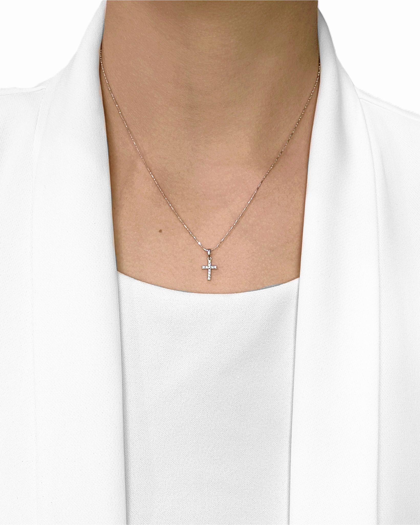 Élevez votre élégance quotidienne avec ce pendentif en forme de croix rayonnante, délicieusement réalisé en or blanc 18 carats et orné de 11 diamants ronds de taille brillant sertis pour un total de 0,07 ct. Chaque gemme a une couleur G-H et une