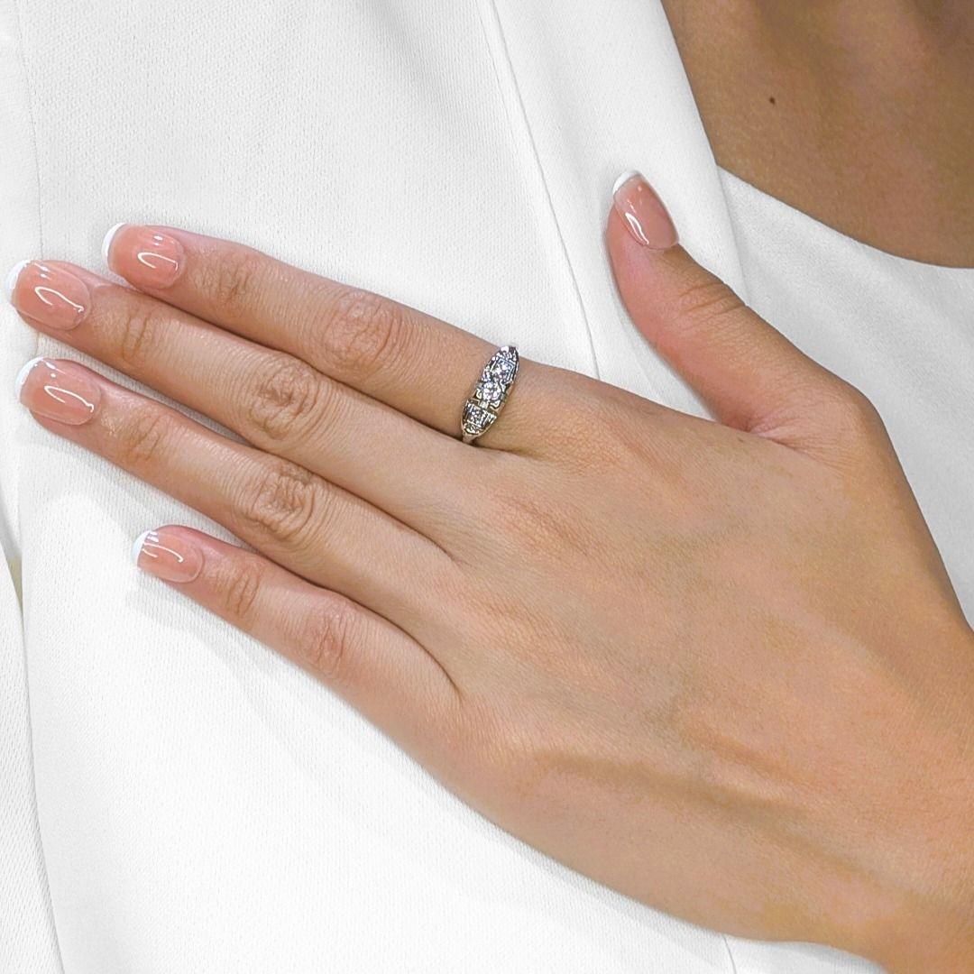 Un tesoro senza tempo dal fascino antico, questo anello vintage presenta tre diamanti naturali rotondi con taglio a brillante per un totale di 0,35 carati, ciascuno con un eccezionale colore F e una purezza VS. Il trio di diamanti è incastonato in