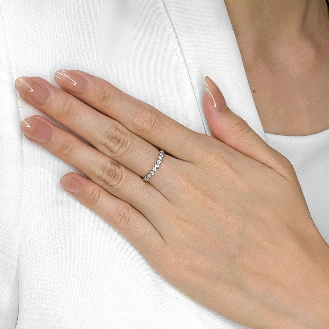 A subtle sparkle, a delicate band from Gold Heart, ready to add a touch of refined elegance to your jewelry collection. This pre-owned 14K white gold ring features nine round brilliant diamonds, totaling 0.36ct, their G-H color and VS clarity