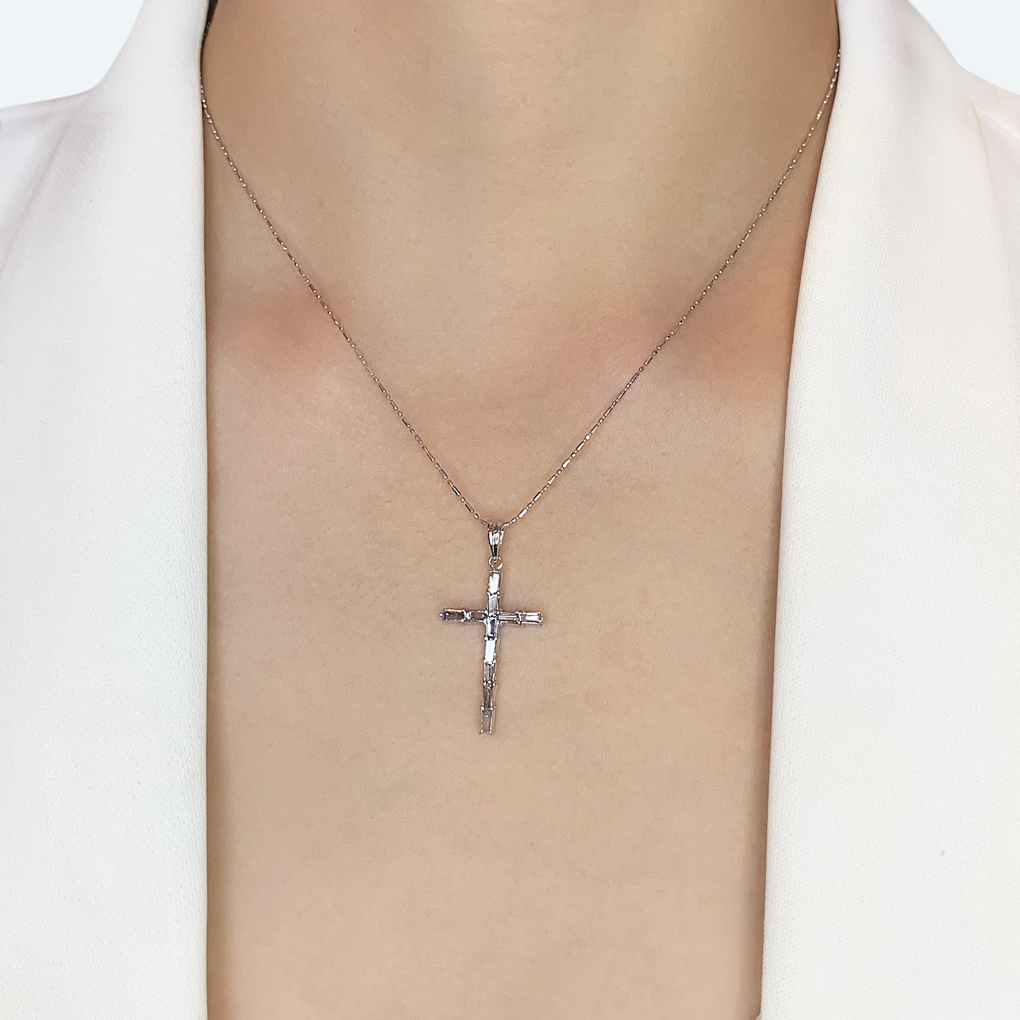 Abbraccia una bellezza senza tempo con questo squisito ciondolo a forma di crocifisso, realizzato in oro bianco 14 carati. Ornato da 11 diamanti naturali affusolati, questo pendente vanta un peso totale di 0,44 carati. I diamanti hanno una