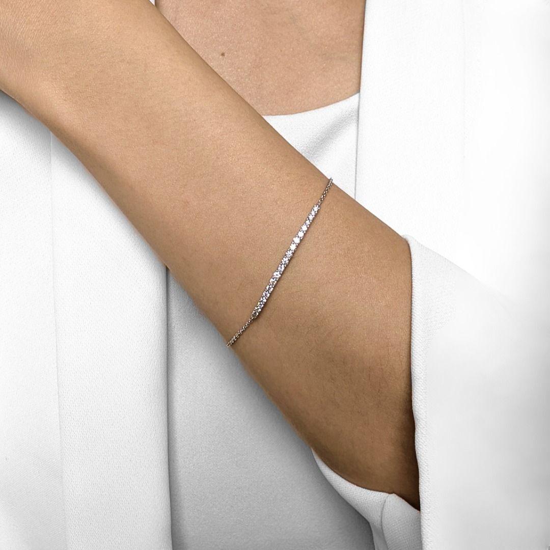 Mince, tranchant et conçu pour briller. Ce bracelet de ligne minimaliste présente 19 diamants ronds de taille brillant (0,57 ct au total), de couleur G-H et de pureté VS, sertis dans une rangée nette d'or blanc 18 carats. Avec un poids plume de 2,65