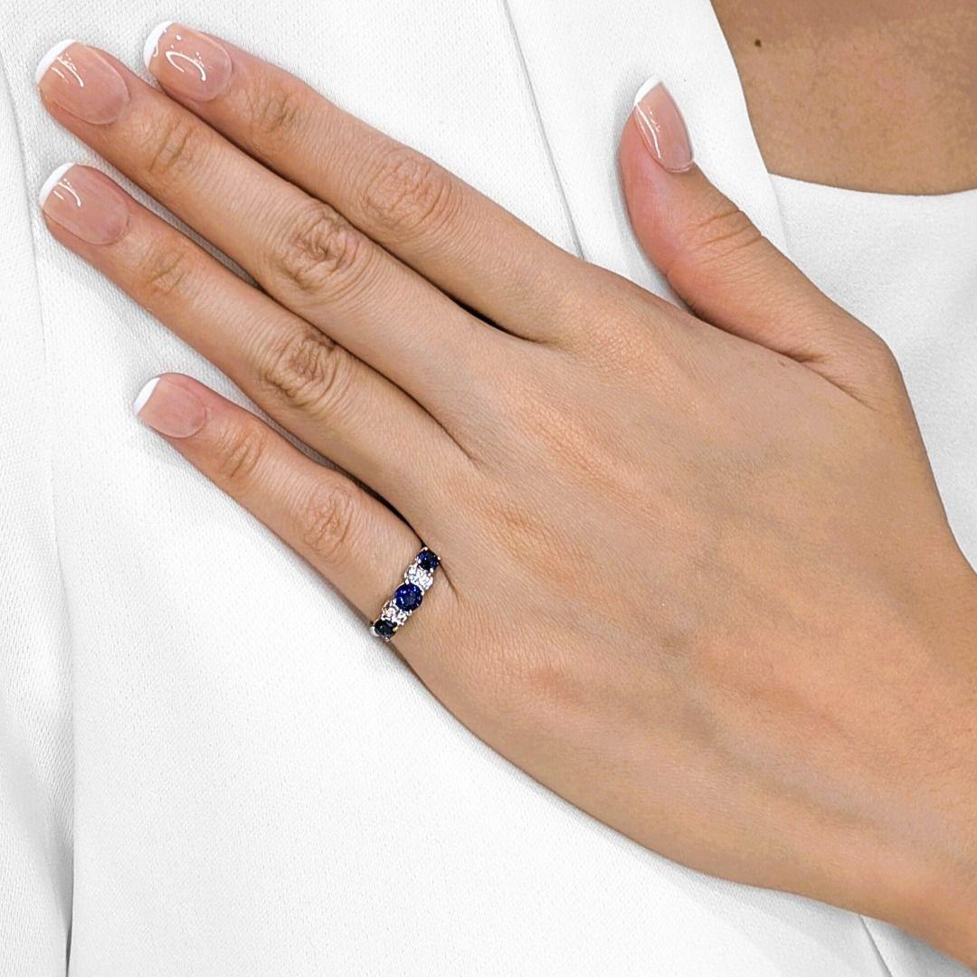 Trois saphirs bleus brillants (0,66 ct au total) illuminent le centre de cette bague d'un éclat profond et velouté, leurs tailles rondes scintillant d'une intensité royale. Encadrant les saphirs, quatre diamants naturels (0,08ct au total, couleur G,