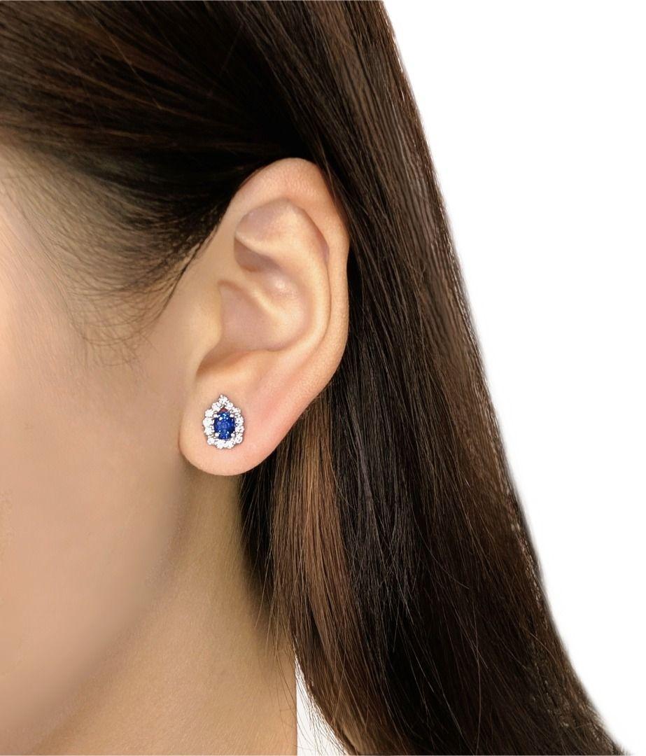 Zeitlose Eleganz trifft auf leuchtende Farben in diesen exquisiten Saphir- und Diamant-Ohrringen. Jeder Ohrring besteht aus einem tiefblauen ovalen Saphir von insgesamt 0,38 ct, umgeben von einem schillernden Halo aus 28 runden Brillanten (insgesamt