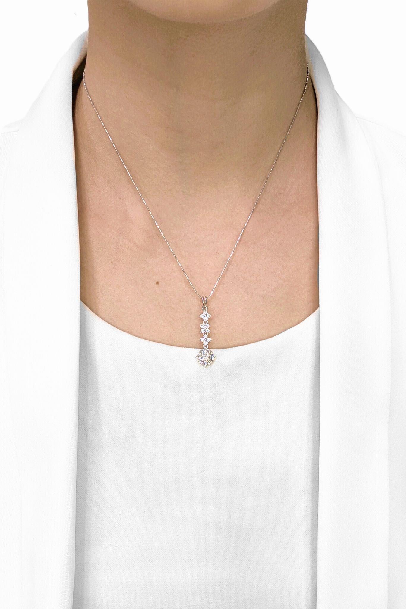 Indossa questo magnifico ciondolo a goccia, accuratamente creato in oro bianco 18 carati, per accentuare la tua scollatura. Il design presenta un interessante flusso di diamanti a grappolo che termina in un punto focale più grande e brillante alla