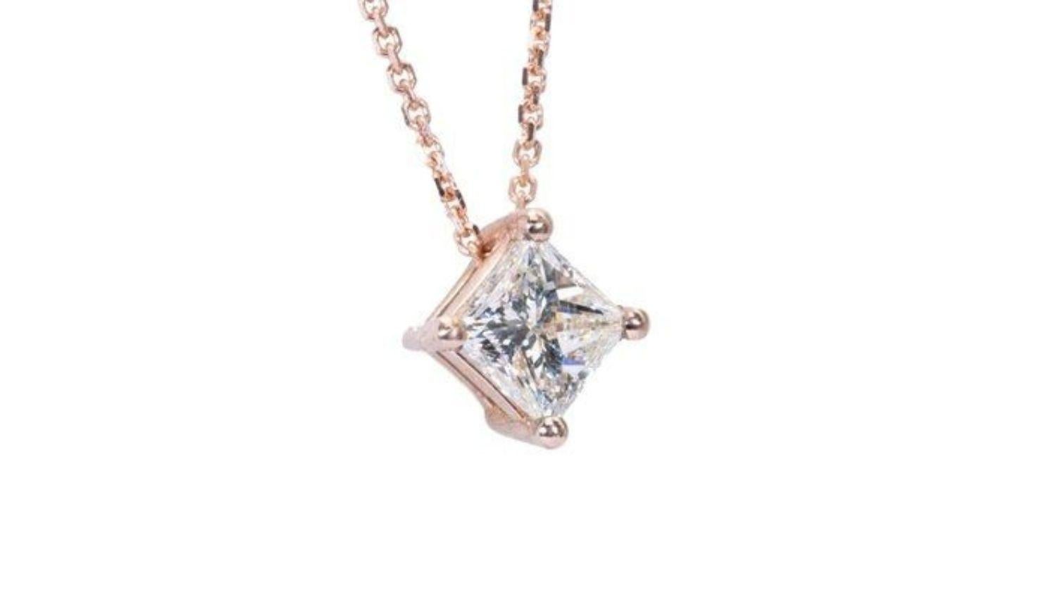 This captivating necklace showcases a dazzling 0.91 carat princess cut diamond, poised to steal the spotlight and become your new forever favorite. The precise facets of the princess cut dance with light, creating a mesmerizing kaleidoscope of