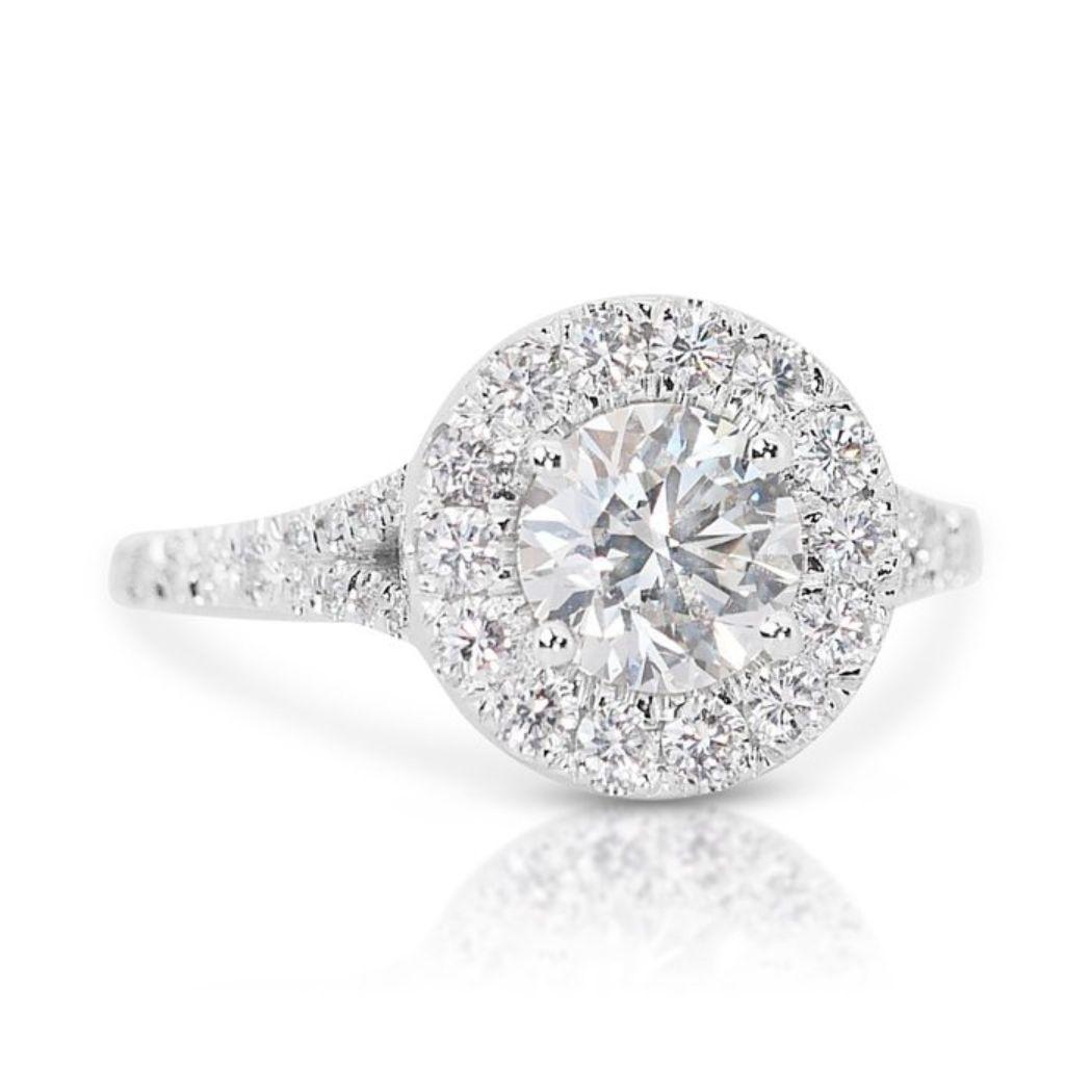 This exquisite ring features a dazzling round brilliant-cut diamond as its centerpiece, weighing 1.05 carats. The diamond boasts a near-colorless hue, falling within the F-G range, which enhances its brilliance and allure. With a clarity grade of