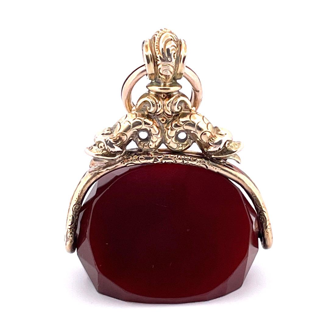 Elevate your style with our extraordinary 10K yellow gold Spinning Carnelian Watch Fab Pendant. This exquisite pendant showcases a beautiful carnelian stone that spins within an intricate gold holder. The captivating carvings on the gold holder add