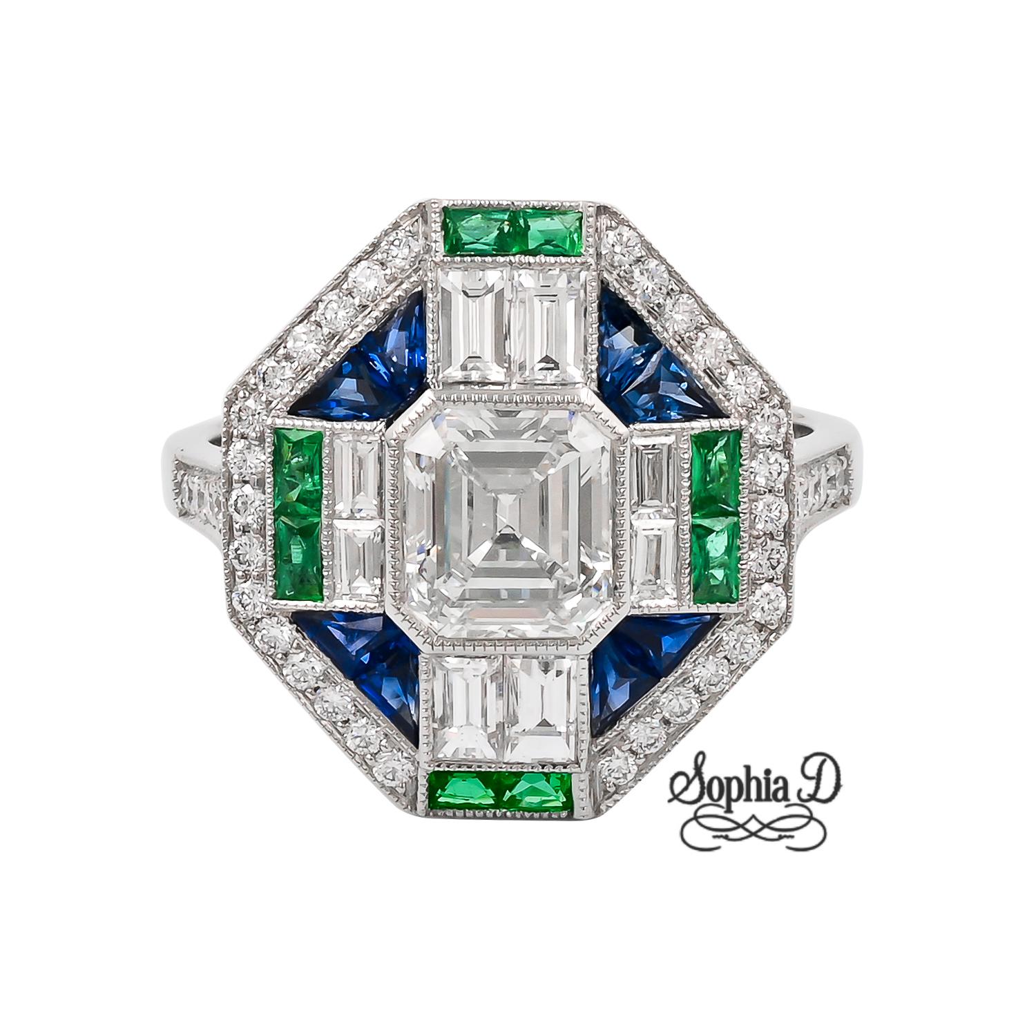 Three gems Art Deco ring by Sophia D. Set in platinum, the ring features a cushion cut center diamond that weighs approximately 1.15 carats with 0.09 carats emerald and 0.46 carats sapphires. 

The ring is a size 6.5 and is resizable and stamped