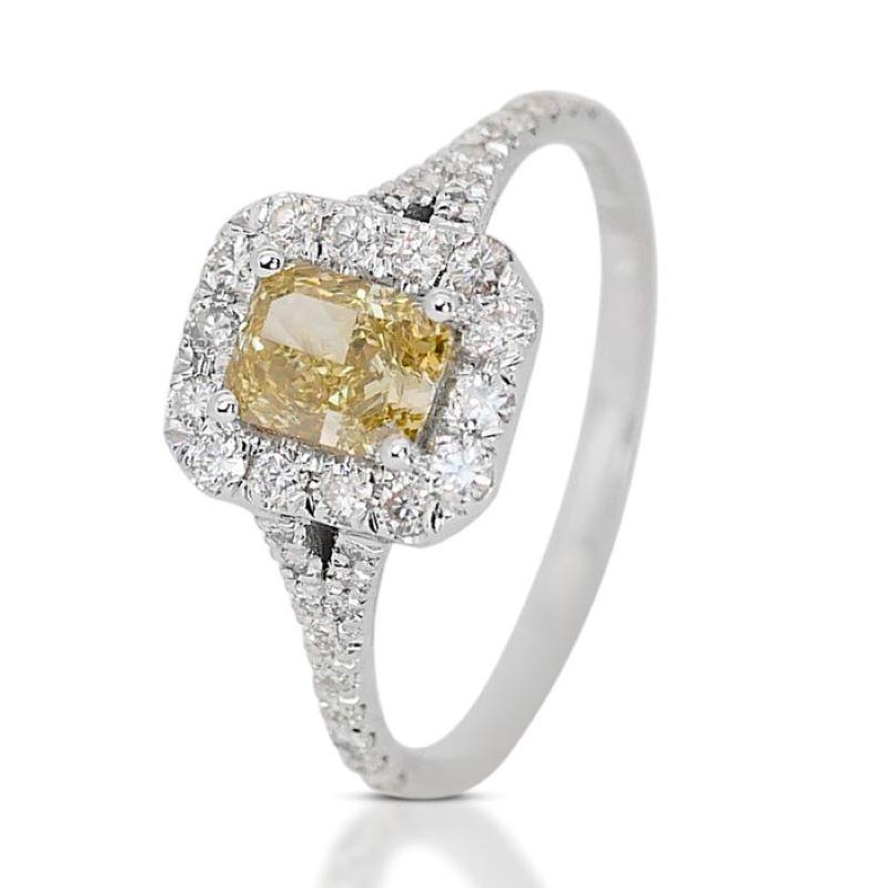 This exquisite ring showcases a magnificent cut cornered rectangular modified brilliant diamond main stone, weighing 0.74 carats. Its breathtaking natural fancy vivid yellow color radiates warmth and vibrancy, making it a truly captivating