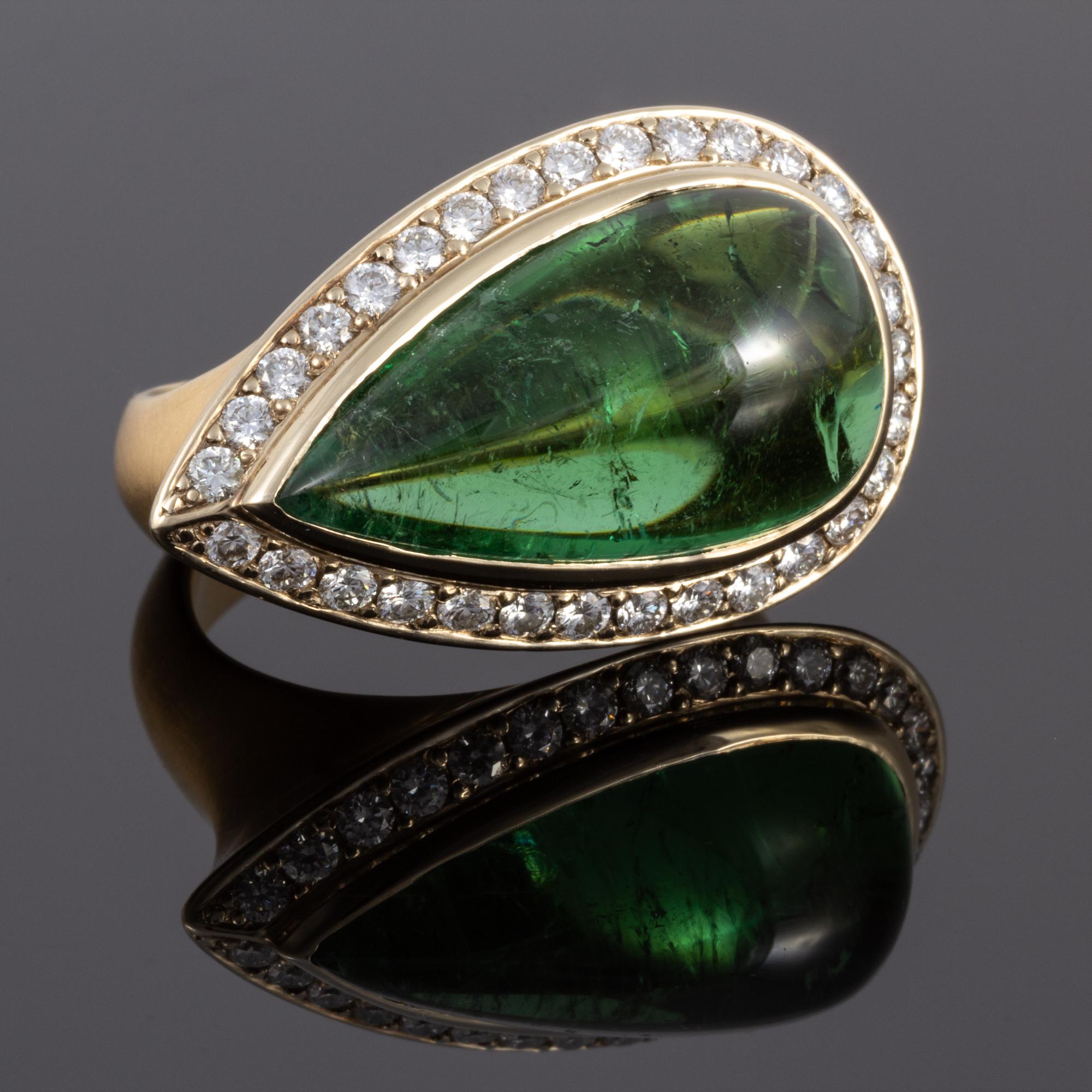 This amazing ring features a large pear shaped Tourmaline cabochon.  Though heavily included, the stone has a vivid saturation.  The center is surrounded by .86 carats of well cut diamonds.  Hand crafted by a master goldsmith in the United States,