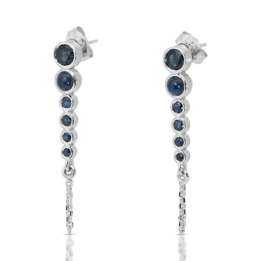 These exquisite earrings showcase a pair of vibrant round brilliant-cut sapphires as their focal point, boasting a total weight of 1.25 carats. The sapphires radiate a captivating blue hue, evoking a sense of elegance and allure. Their transparency