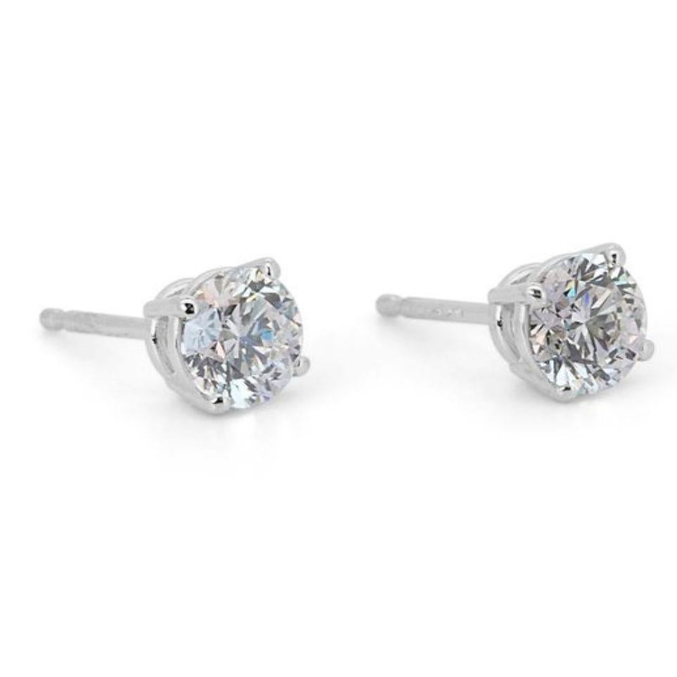 Unleash your inner radiance with these captivating 1.4 carat diamond stud earrings, crafted in luminous 18K white gold for undeniable luxury. Each earring features a mesmerizing Round Brilliant diamond, boasting an extraordinary near-colorless D-E
