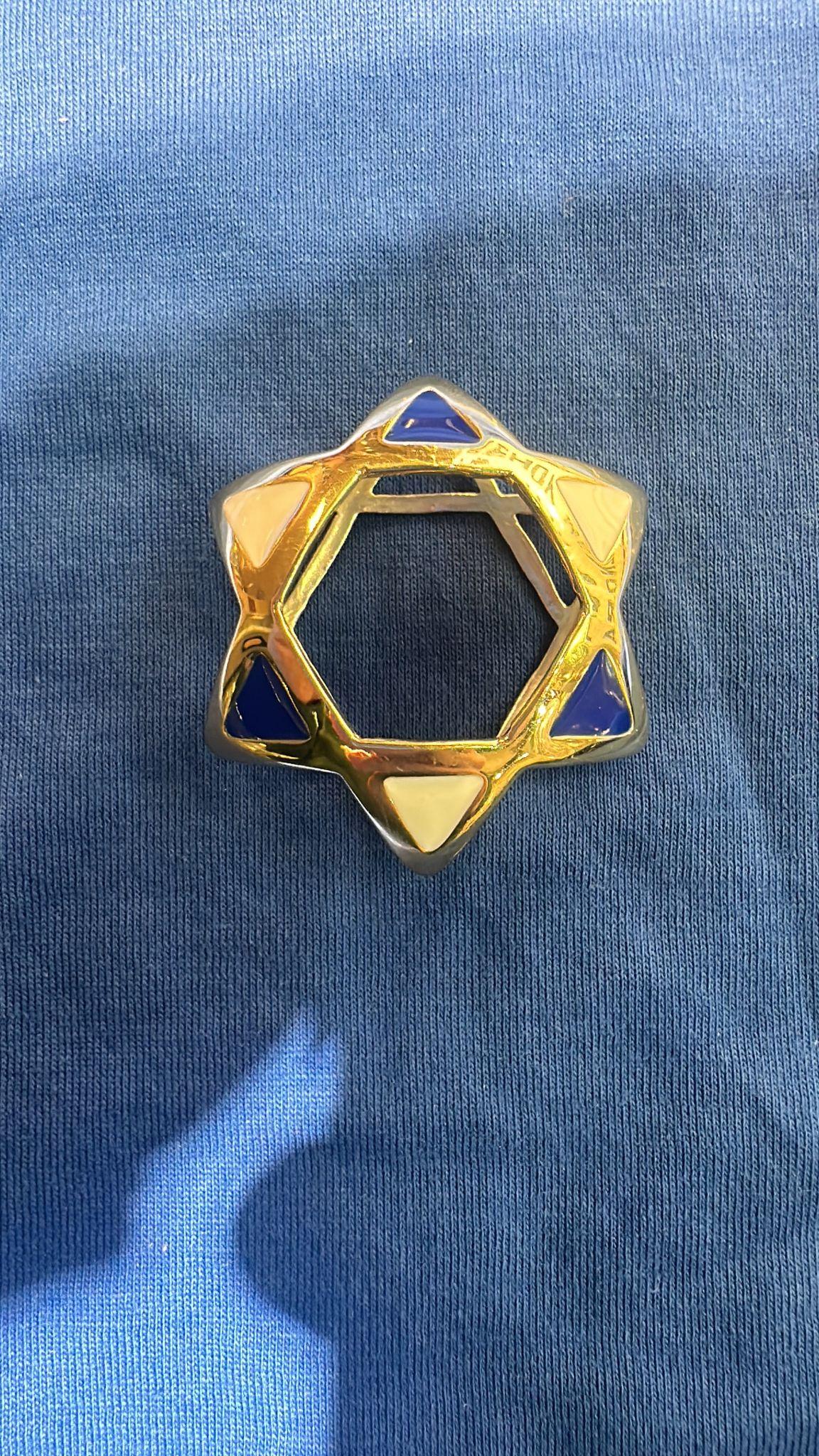 This remarkable 14K gold pendant, weighing 10 grams, is a distinguished creation by Russian jeweler Nikolai Bachmakov in New York. Designed in the form of a striking Star of David, the piece is adorned with deep blue and white enamel accents that