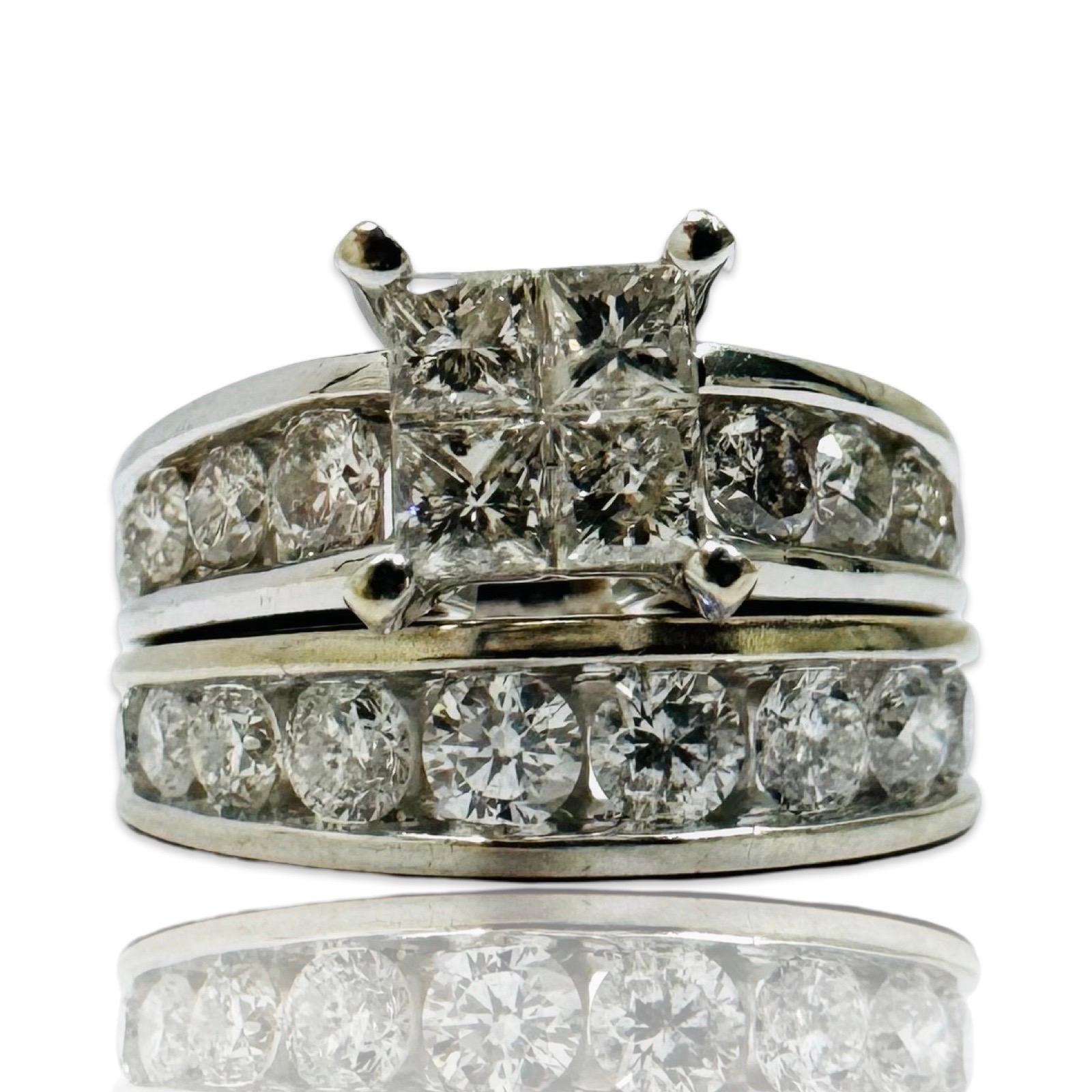 This exquisite 14K white gold diamond wedding set features a total of 3.53 carats of shimmering G-H color, SI clarity diamonds. The engagement ring showcases four striking princess-cut center diamonds flanked by channel-set round brilliant diamonds,