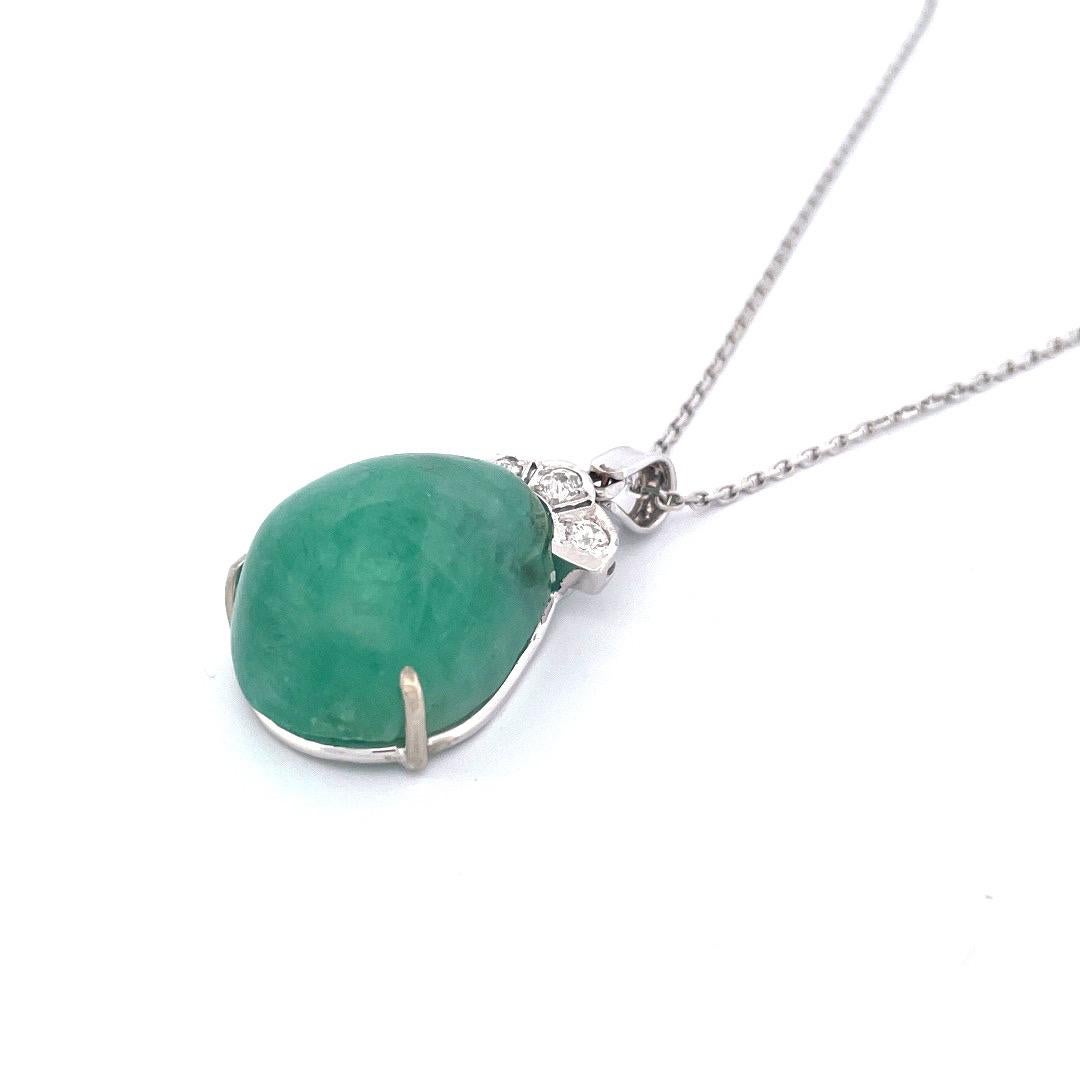 Make a captivating statement with this exquisite 14k white gold natural emerald hand carved necklace. The centerpiece of this necklace is a stunning oval-shaped emerald, weighing 37.58 carats. Adorning the emerald is a regal crown embellished with