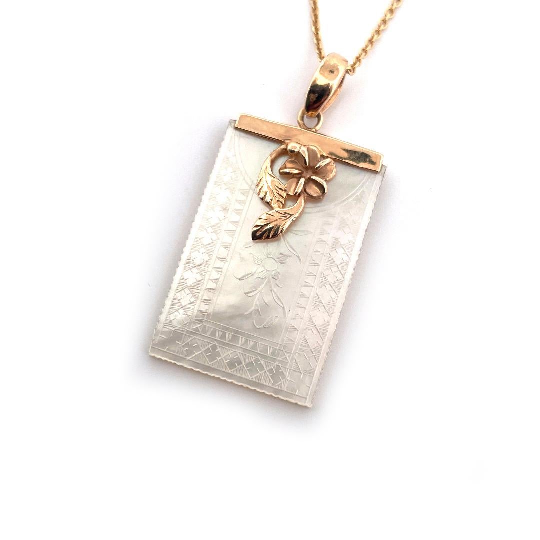 Embrace timeless beauty with our 14K Yellow Gold Engraved Mother Of Pearl Rectangular Pendant Necklace. The pendant showcases an intricately engraved floral design on a lustrous mother of pearl centerpiece, exuding a captivating iridescent glow. A