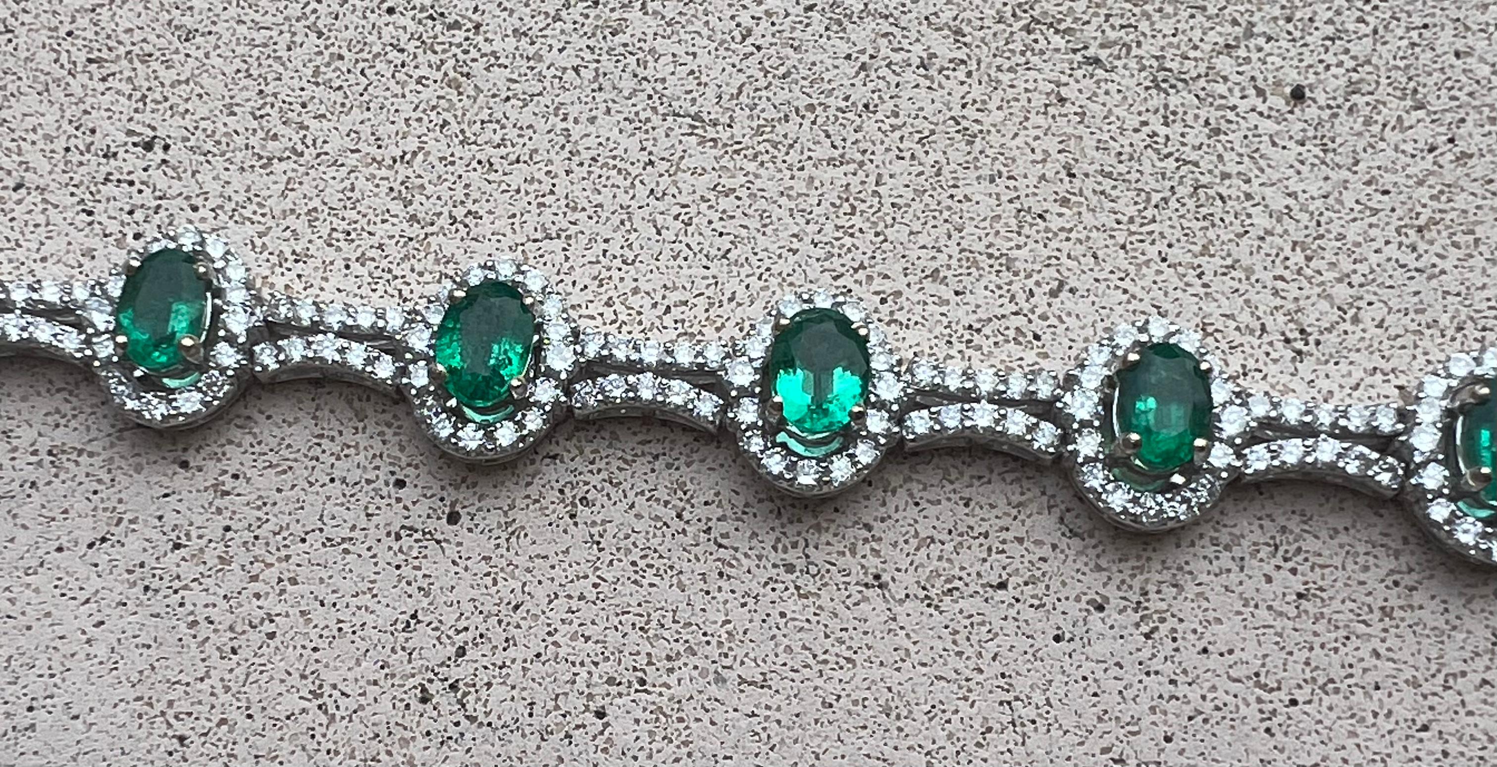 Very exquisite, estate 15.80 carat emerald and diamond 18 karat white gold tennis or line bracelet features 10 beautifully matched, oval cut emeralds mounted in 4 prong stations, surrounded by a halo of the most sparkling round brilliant diamonds