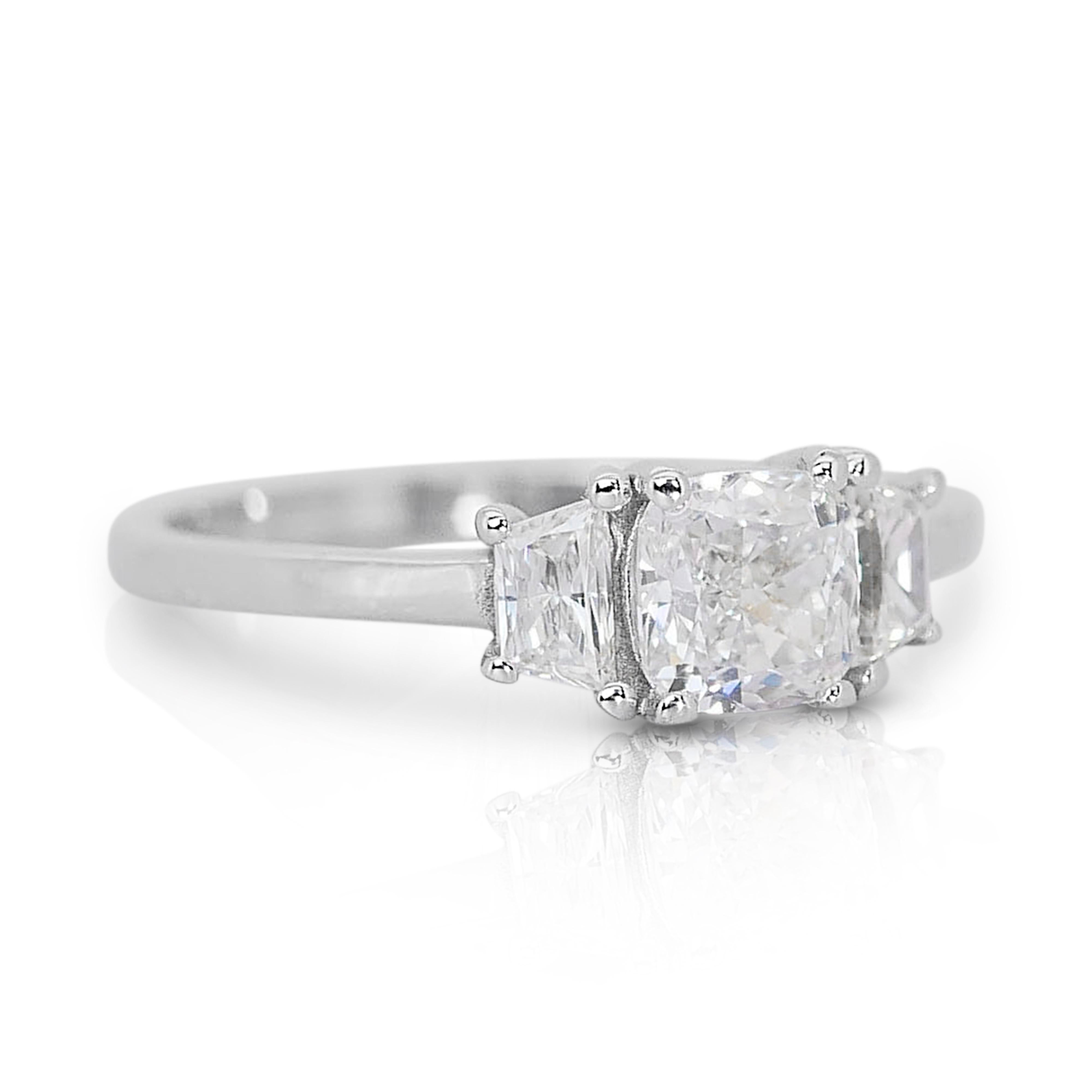 At the heart of this exquisite ring lies a brilliant 0.90-carat Cushion Modified Brilliant diamond, boasting a radiant G color and mesmerizing VS2 clarity. Its expertly cut facets enhance its sparkle, creating a captivating display of light with