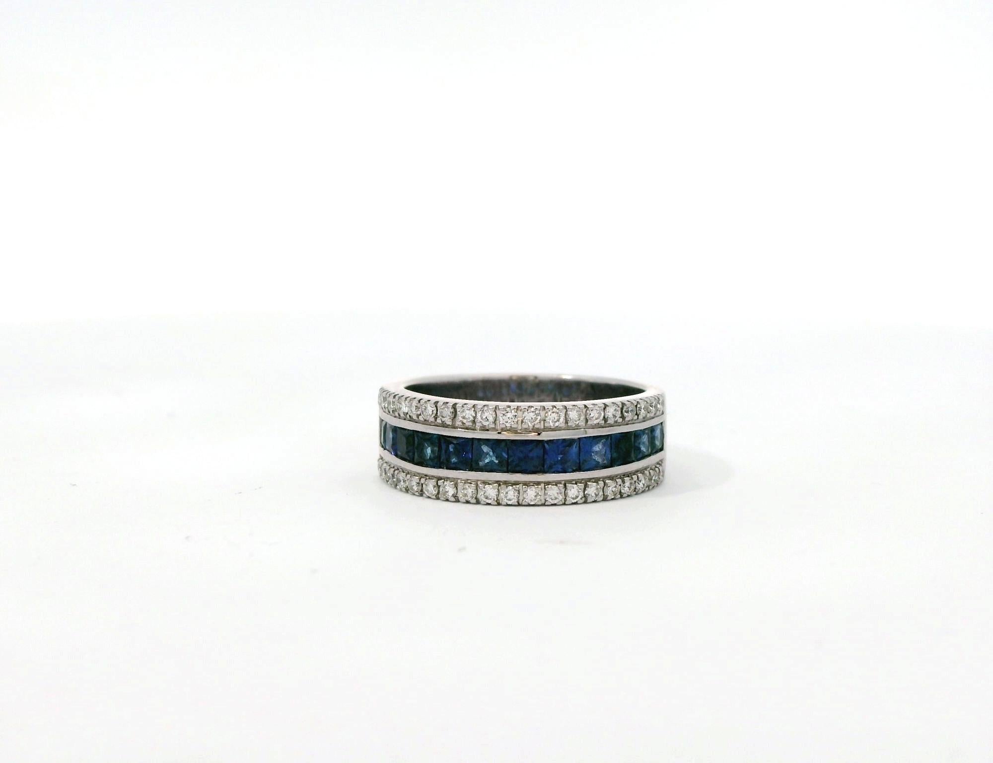  This elegant ring features a stunning combination of diamonds and sapphires set in white gold. The design includes two rows of brilliant-cut diamonds on the top and bottom of the band, with a central row of deep blue square-cut sapphires. The