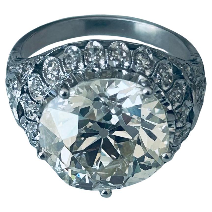 Presenting a stunning piece of fine jewelry: This luxurious ring features a magnificent 6.5-carat Old European Cut central diamond that dazzles with its vintage charm and timeless brilliance. Surrounding the central stone are 34 smaller diamonds,
