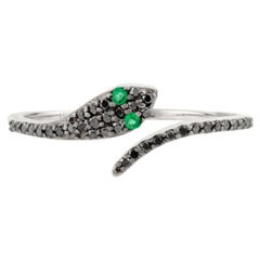 Exquise bague serpent en or blanc 18 carats - yeux d'émeraude et diamants noirs sertis en pavé
