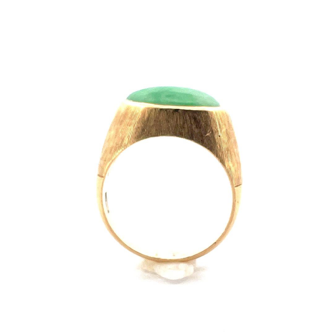 Elevate your style with our exquisite 18K Yellow Gold Jadeite Textured Ring. This ring features a beautifully textured band crafted from 18k yellow gold. At the center rests a stunning oval-shaped jadeite stone, radiating its vibrant green