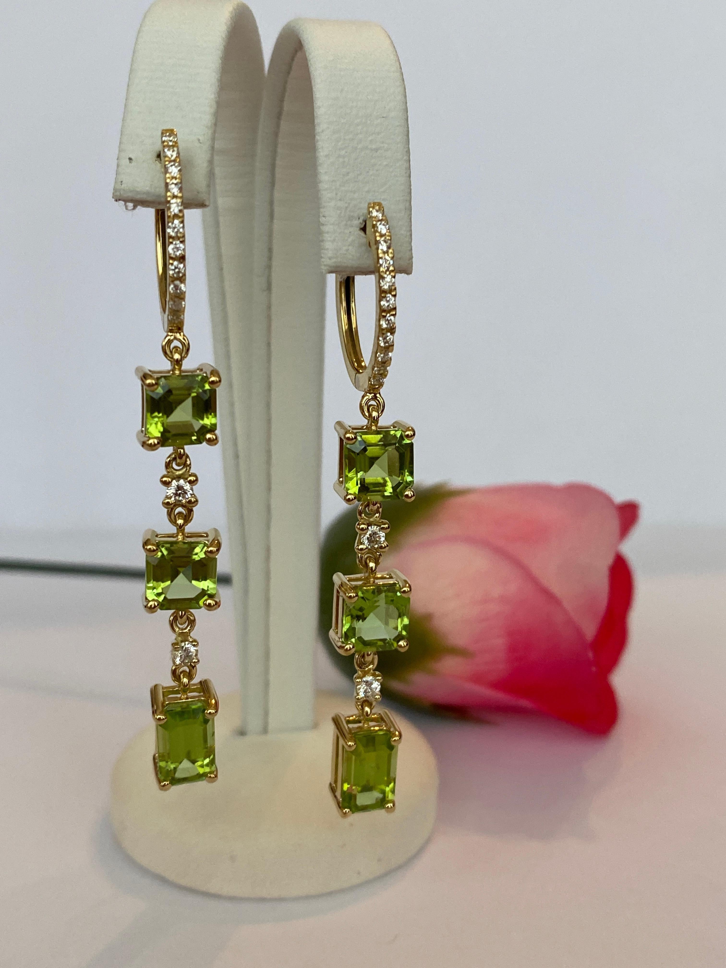 Elevate your elegance with these captivating 18K Yellow Gold Peridot and Diamond Dangle Earrings—a radiant expression of refined taste and timeless luxury.
At the heart of each earring lies a luscious, vivid green peridot, expertly cut to showcase