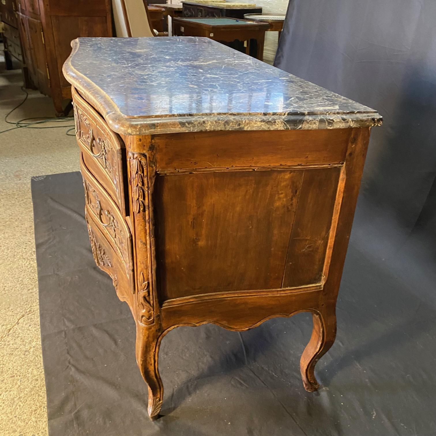 Eccezionale esempio di commode in noce intagliato del tardo XVIII secolo Luigi XV  con ornamenti in bronzo cesellato e dorato, la parte anteriore si apre con due grandi cassetti, sopra un grembiule decorativo intricato e gambe cabriole ricurve;