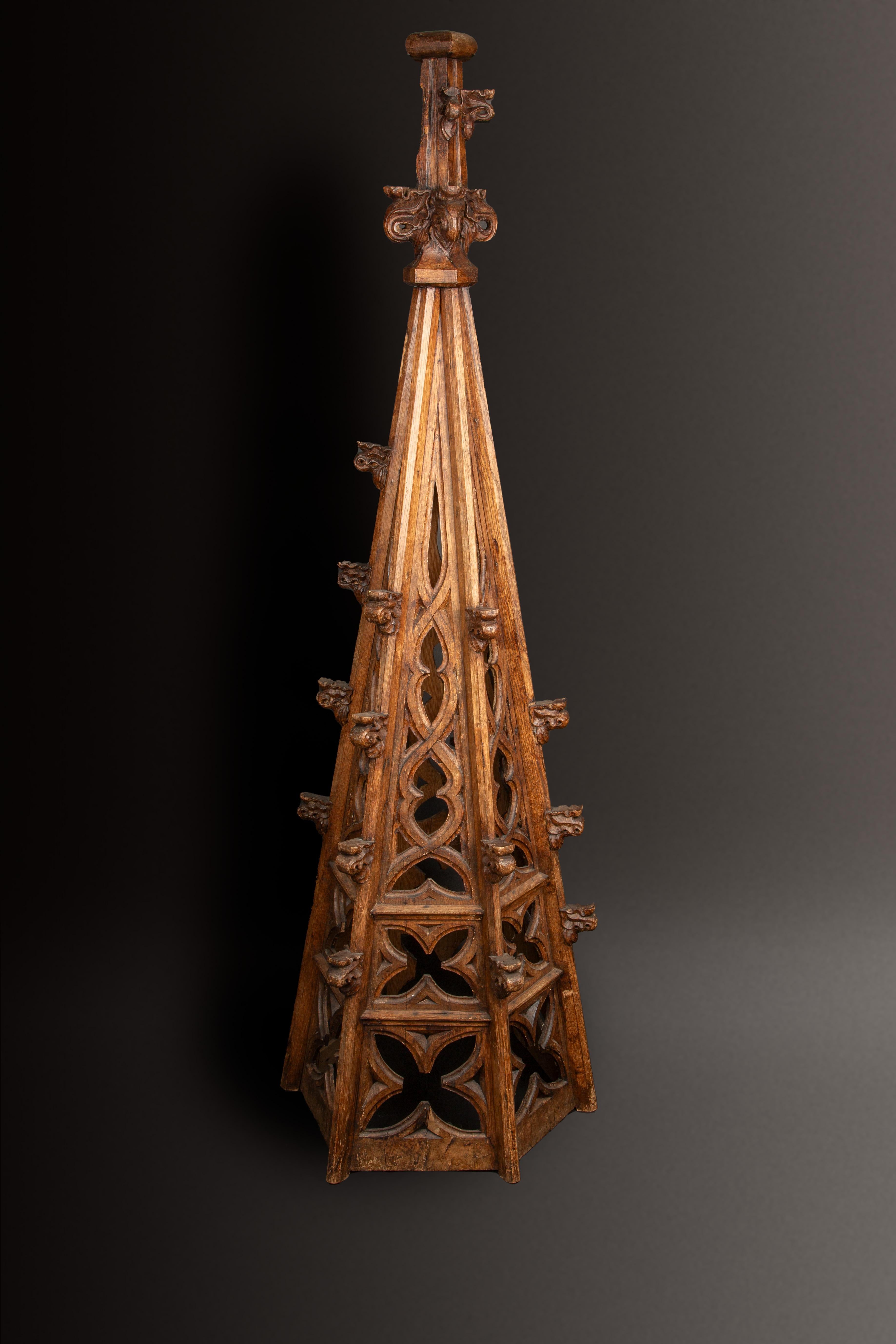 Esta exquisita aguja gótica del siglo XVIII, de 73 pulgadas de altura, es un notable ejemplo de ornamentación arquitectónica tallada a mano de la época. Fabricada en madera maciza, esta aguja muestra la intrincada y meticulosa artesanía