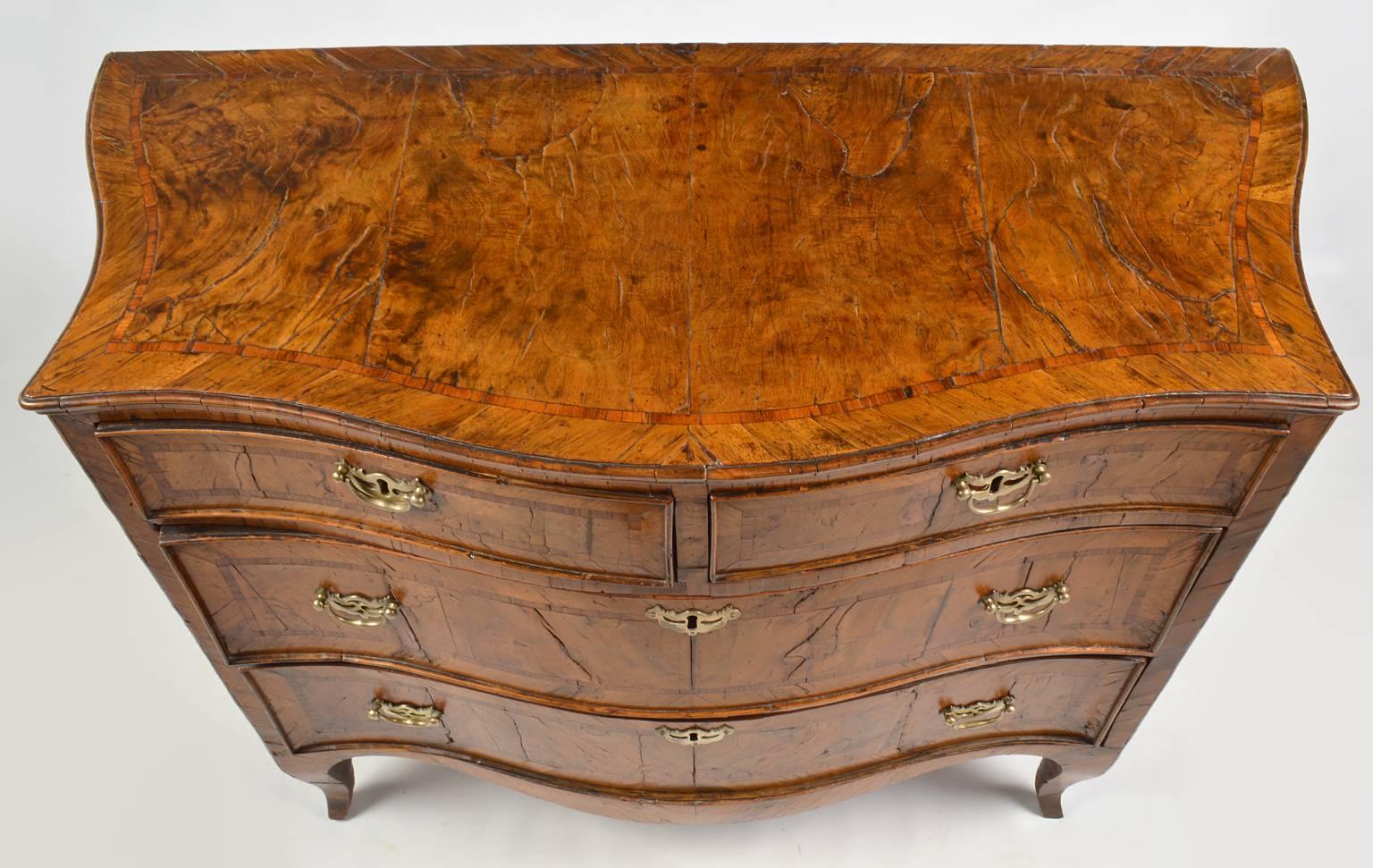 This fine Italian parquetry commode is a prime example of the Austrian dominated North Italian interpretation of French Louis XV influences. It is retaining the symmetrical configuration of previous styles renewed with serpentine and cabriole