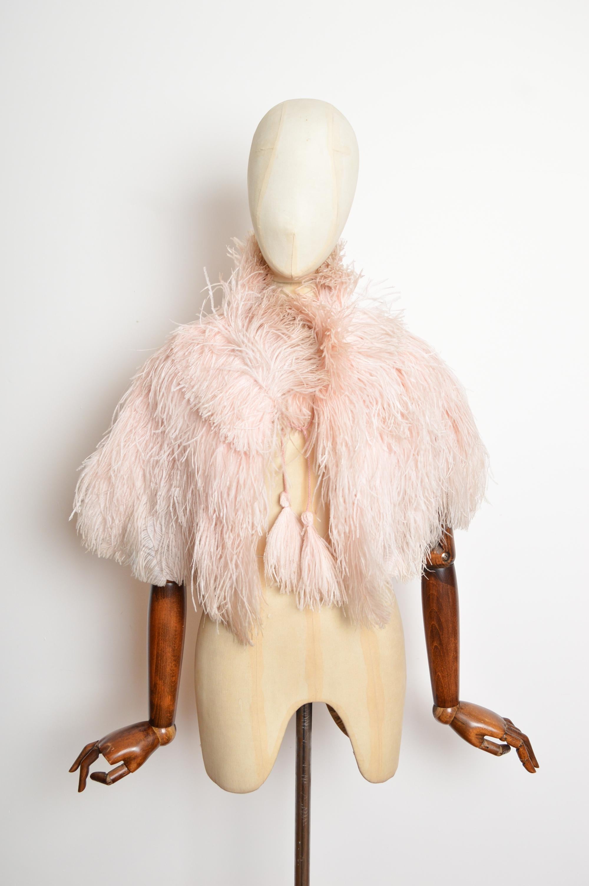 Squisita stola a mantello in piume di struzzo rosa polveroso degli anni '30
Una straordinaria stola di piume di struzzo degli anni '30, in una polverosa tonalità di rosa pallido. Presenta una fodera in crepe di seta cucita a mano e lacci con nappe a