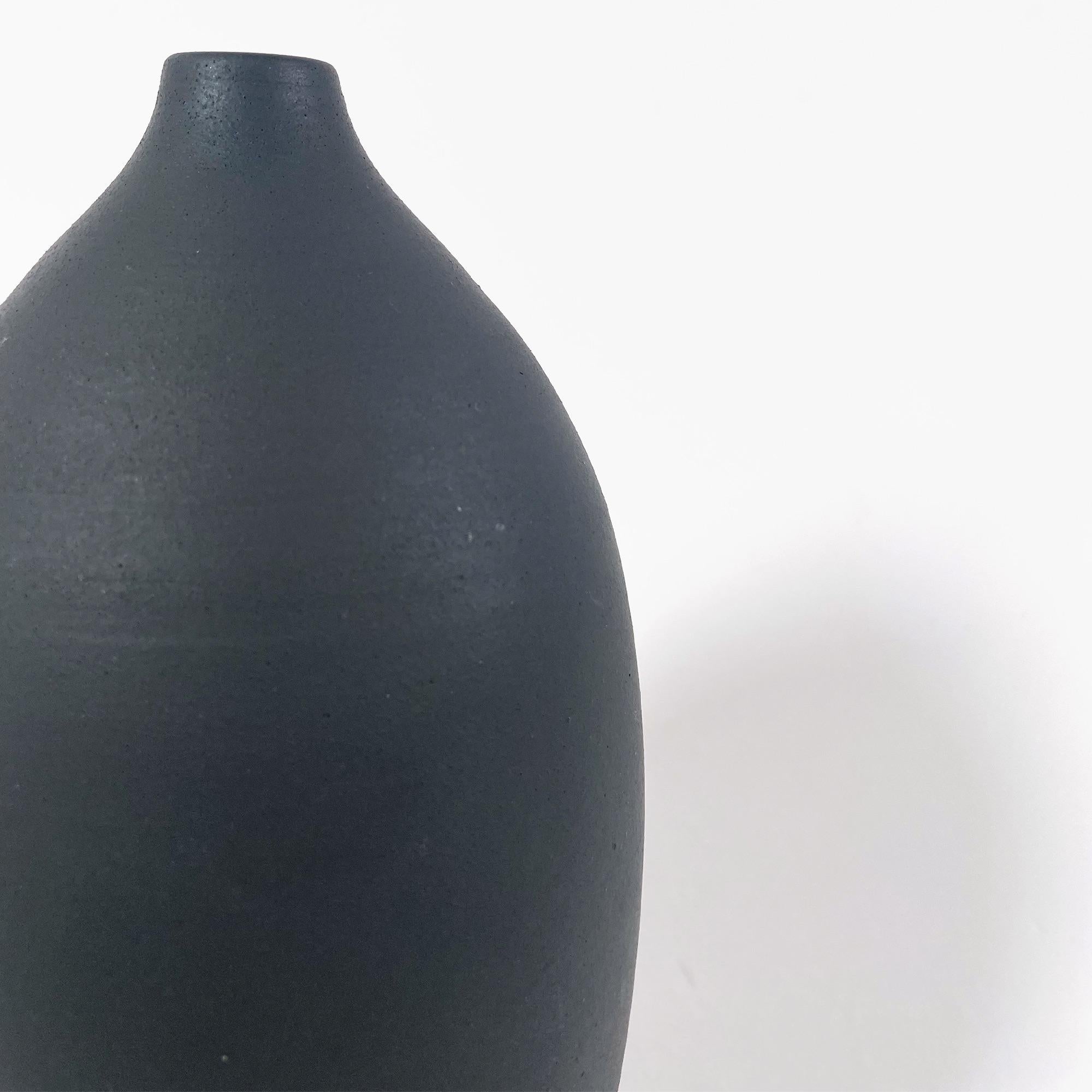 Scopri l'eleganza di questo splendido Soliflores in ceramica nera, una vera e propria testimonianza della maestria artigianale degli anni '40. Con un'altezza di 28 cm e un diametro di 13 cm, questo vaso presenta un'apertura delicatamente